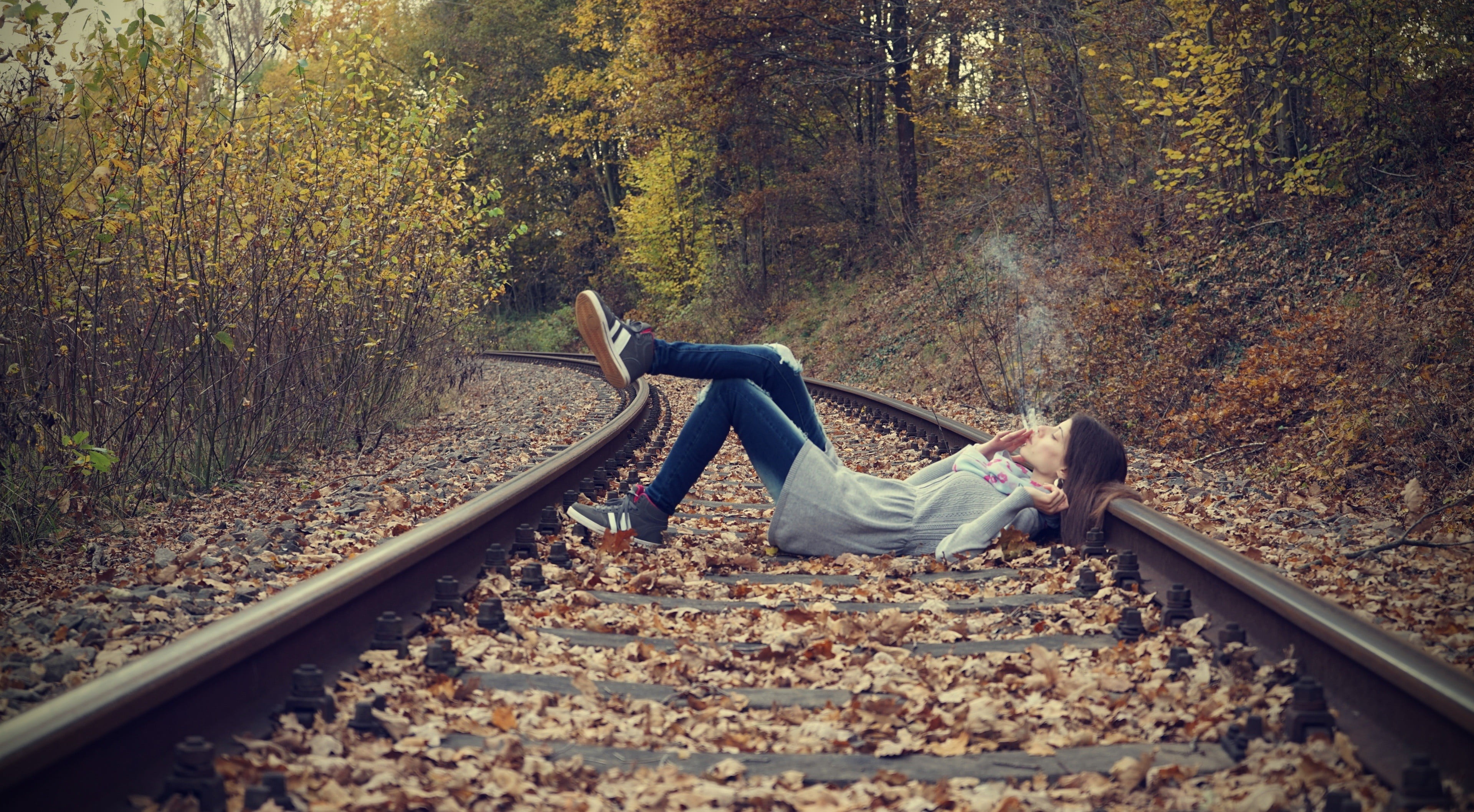 smoking, lying down, leisure activity, day, land, women, nature, rail transportation, real people, full length, autumn, outdoors, young adult, woodland, HD Wallpaper