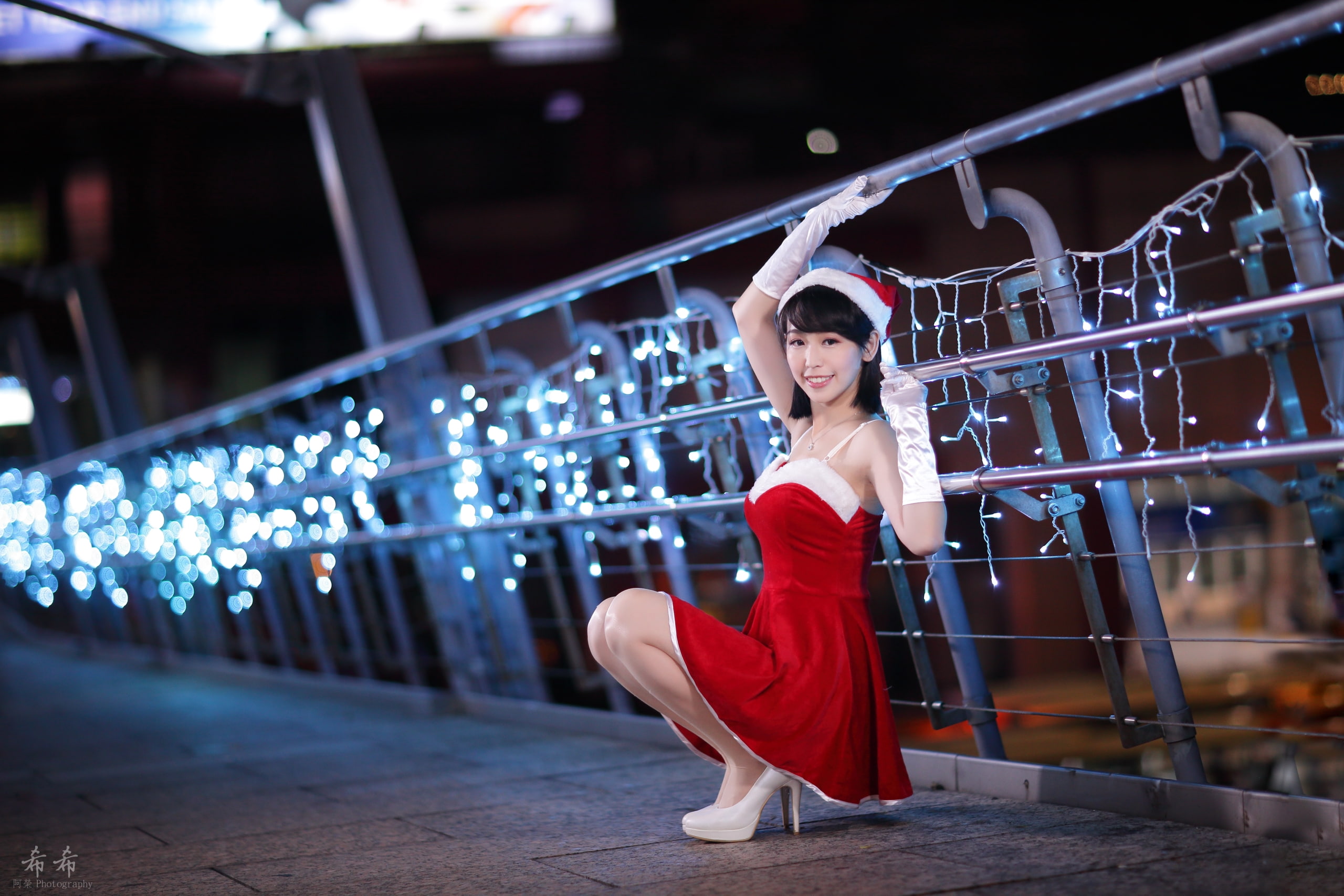 dark hair, outdoors, 2K, dress, Santa costume, christmas lights, railings, Christmas, lights, squatting, looking at viewer, portrait, red dress, Santa girl, HD Wallpaper