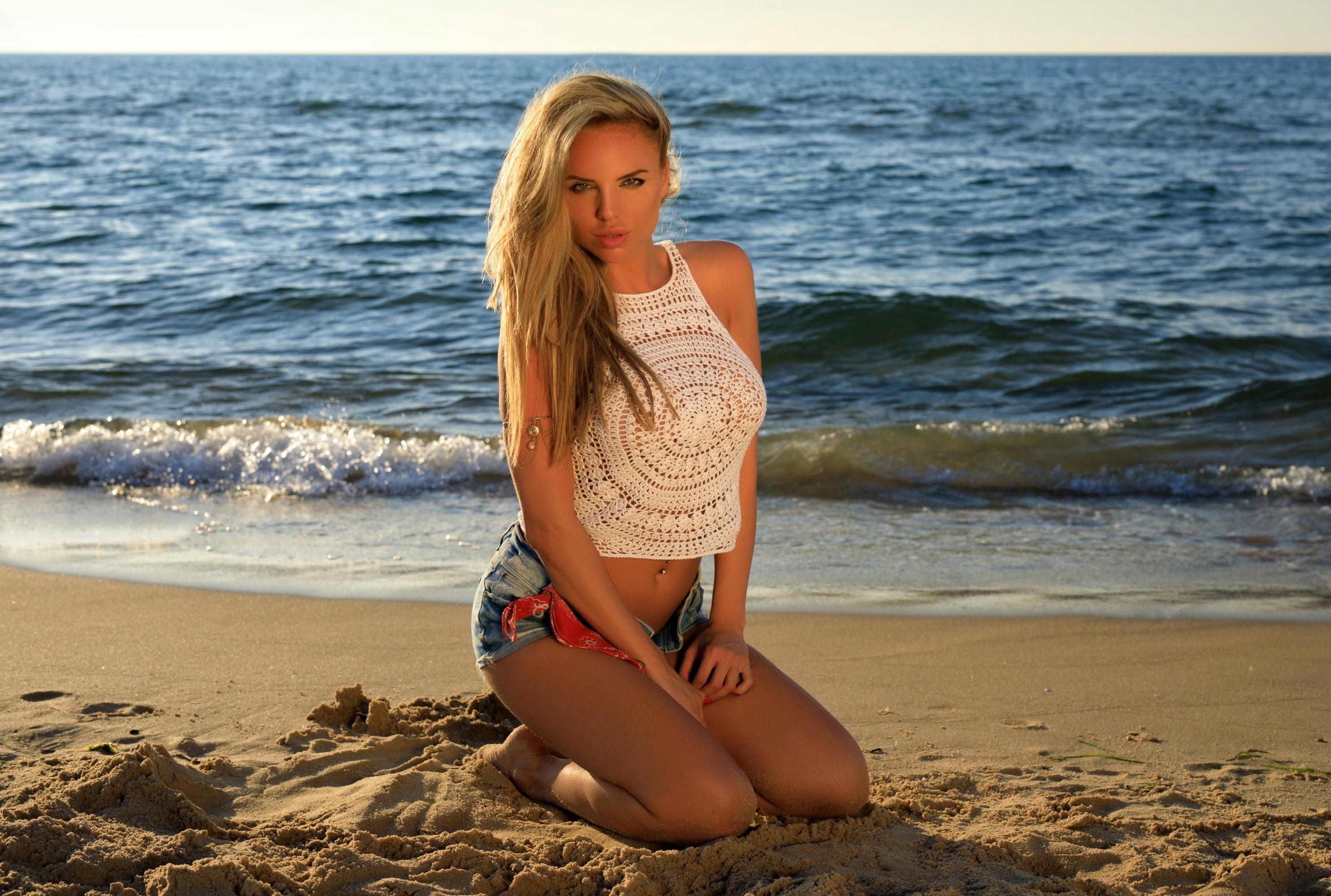Brittie, on the shore, 2K, sea, shorts, sexy, sitting, Mike, makeup, s, beach, beauty, sleeveless, sand, hairstyle, the sun, pose, top, white, horizon, HD Wallpaper
