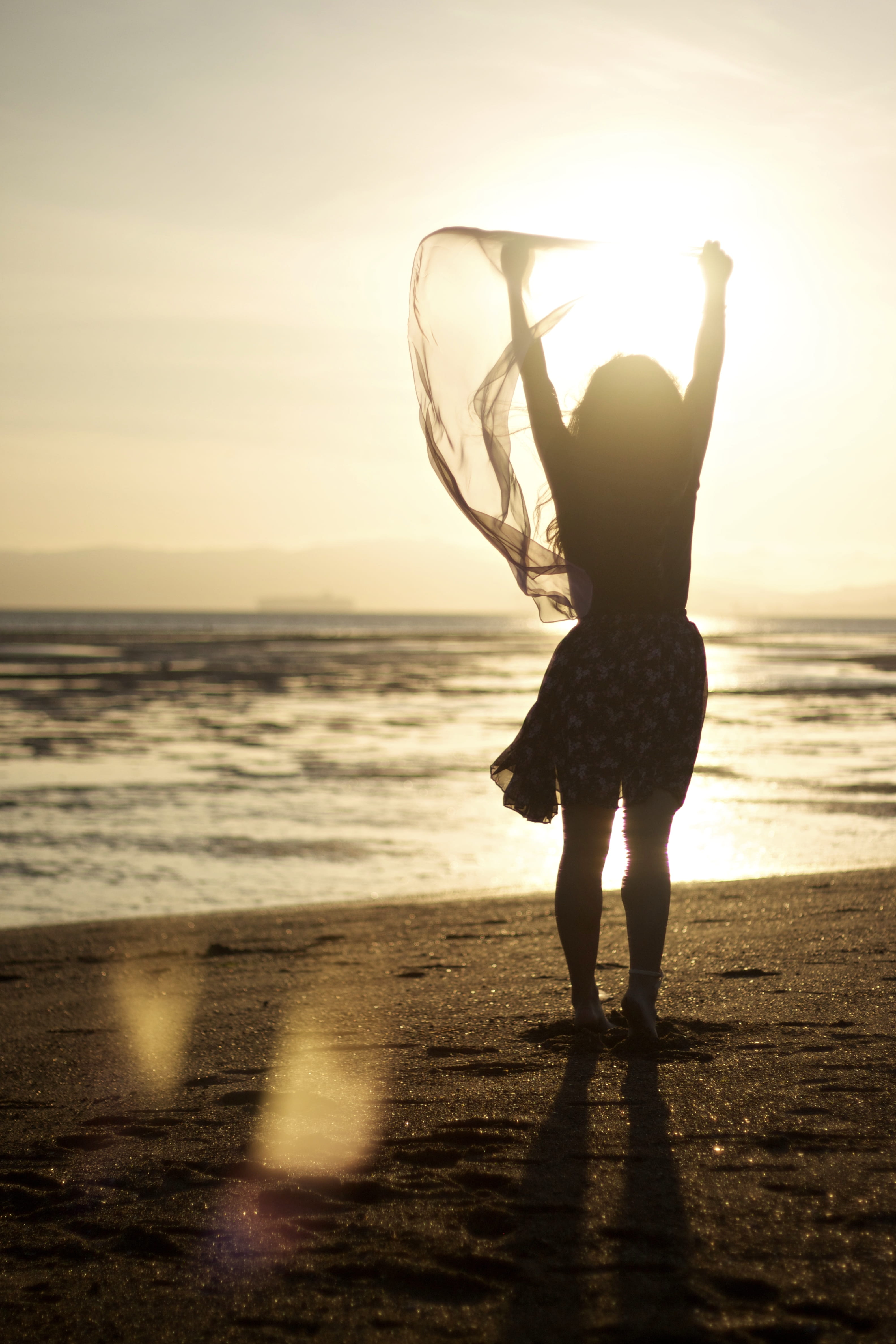 horizon over water, sheer, woman, leisure activity, silhouette, full length, arms raised, sky, rear view, sunlight, water, women, scarf, scenics - nature, Phone HD Wallpaper