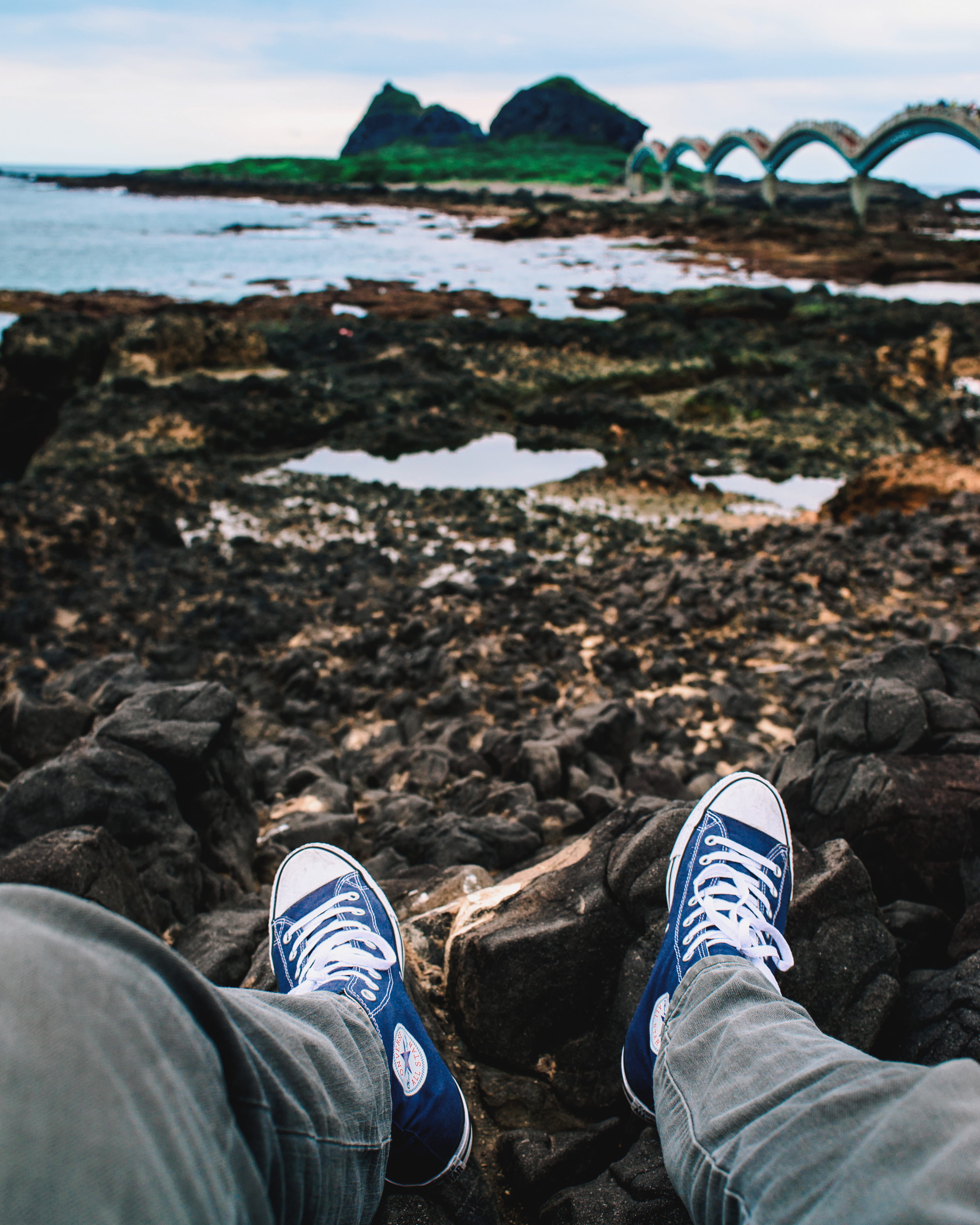 low section, sea, body part, personal perspective, front, men, land, blue, body, real people, human foot, person, shoe, jeans, 4K, leisure activity, stone, Phone HD Wallpaper