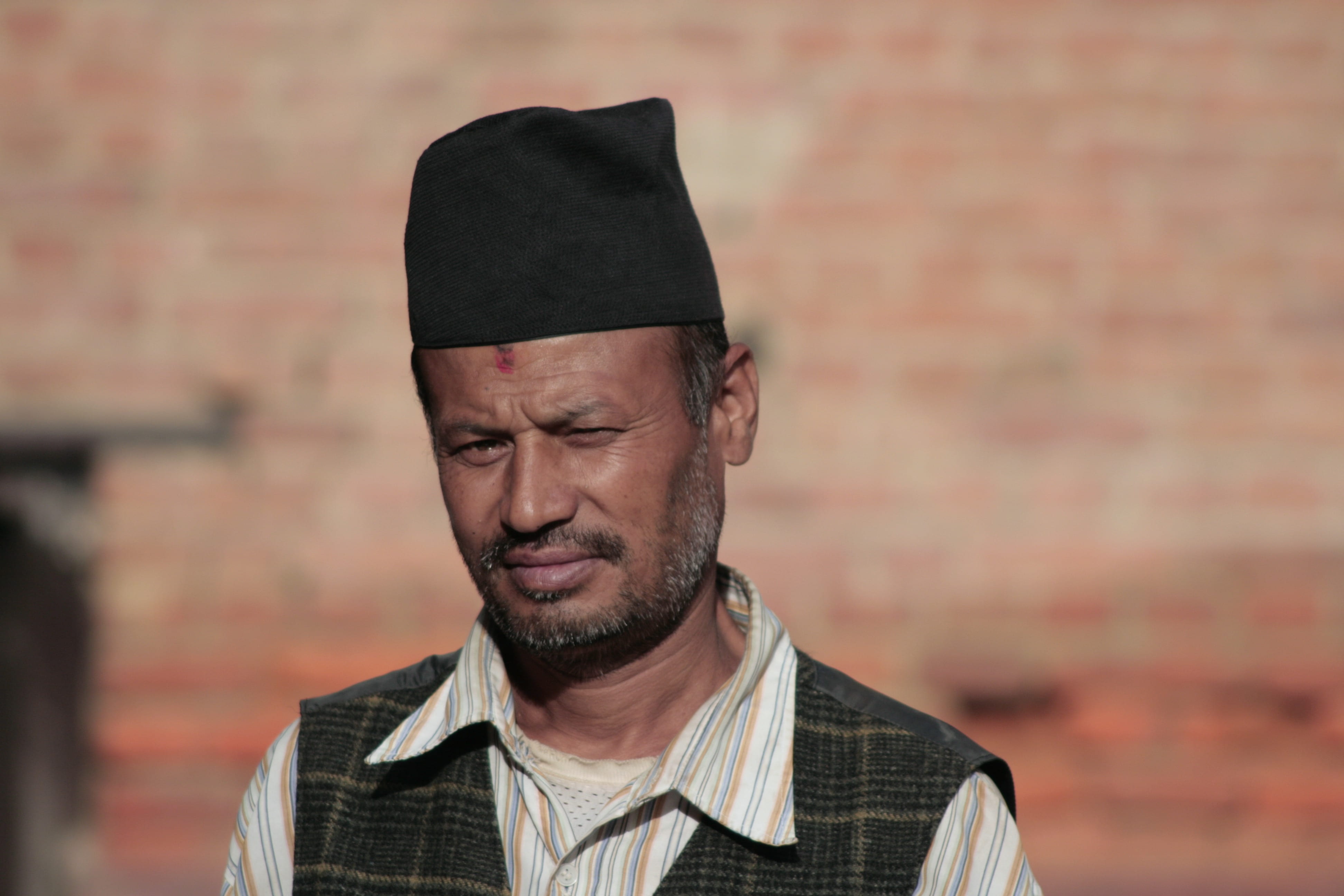 portrait, male, contemplation, brick, front view, cap, face, nepal, day, clothing, wall, adult, outdoors, mature adult, males, looking, emotion, head, individuality, HD Wallpaper