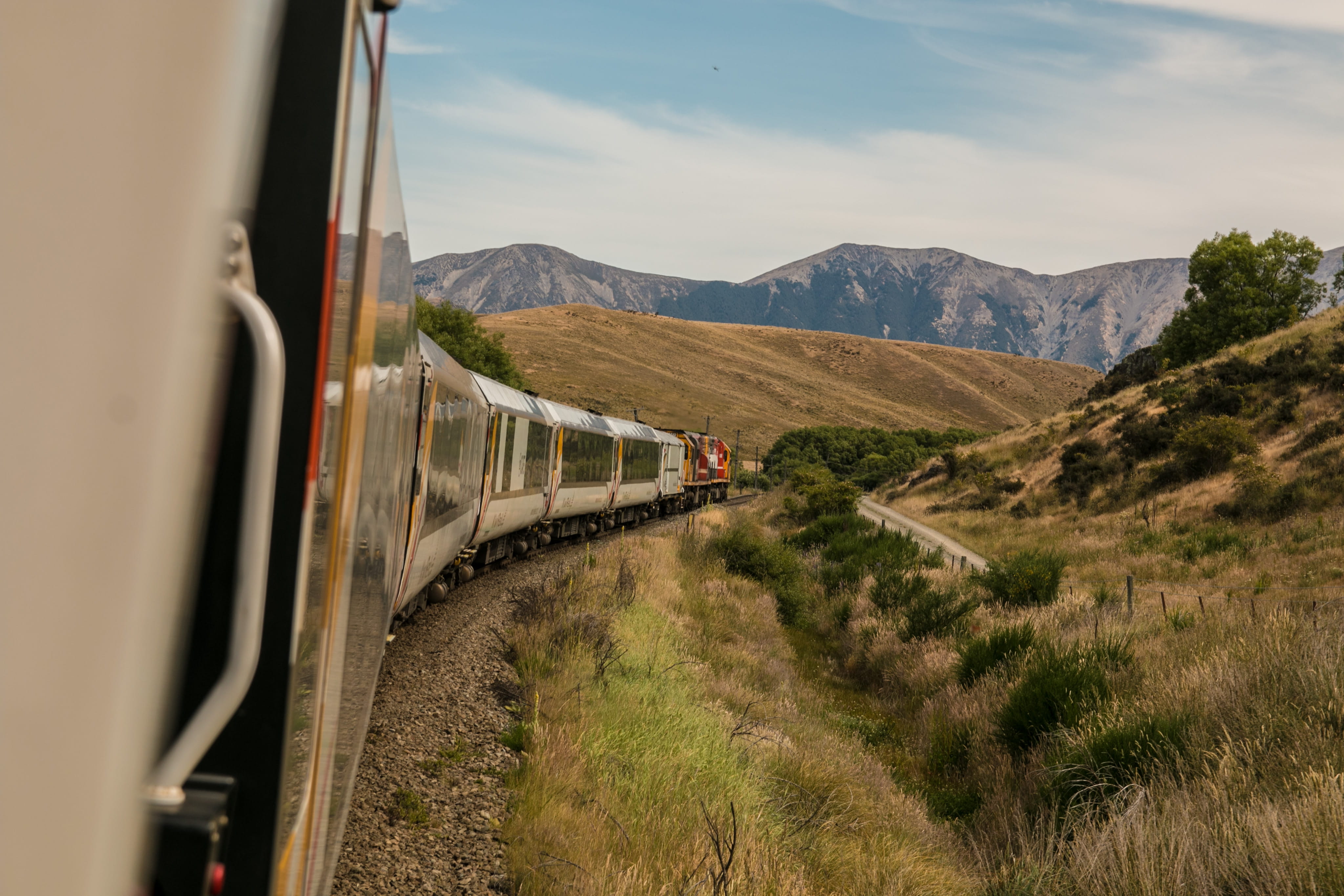 white, rail transportation, train - vehicle, mountain range, on the move, 4K, day, railroad track, distance, journey, dirt road, viaduct, outdoors, clouds, HD Wallpaper