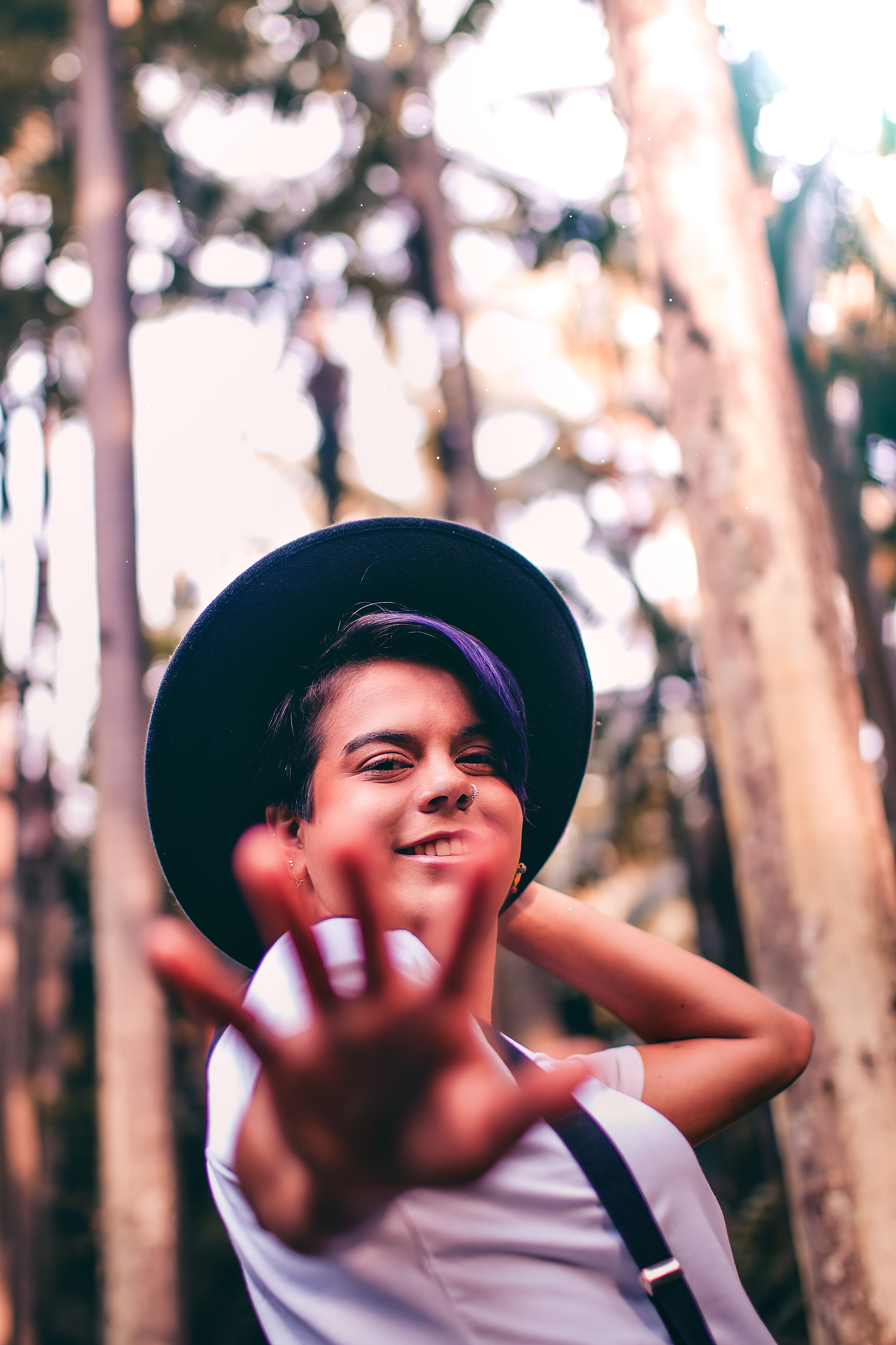 portrait, hat, focus on foreground, tree, plant, blur, white, black, young adult, person, outdoors, fashion, low angle shot, shirt, near, headshot, happiness, Phone HD Wallpaper