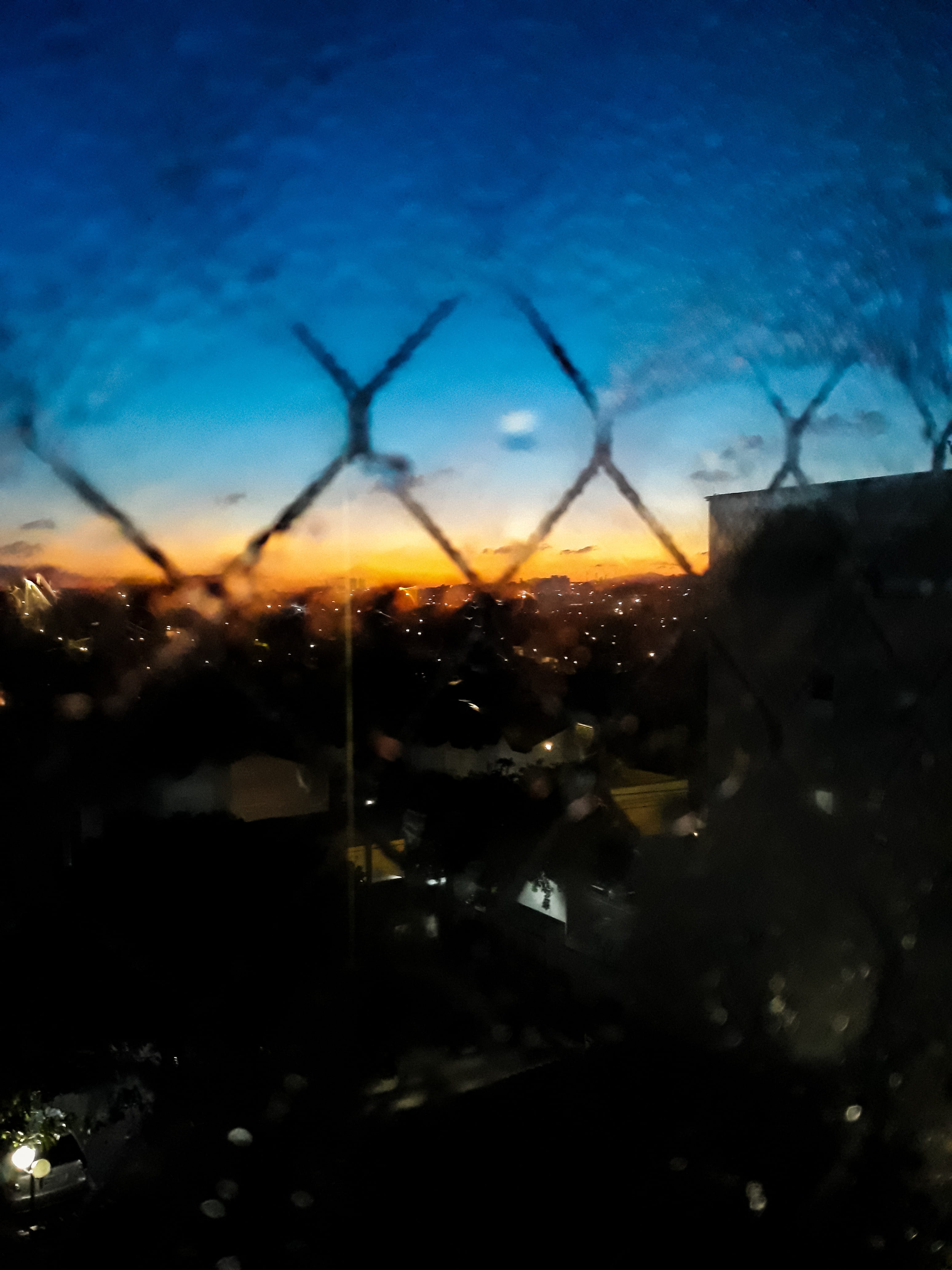 rain, lights, 4K, no people, glass, cyclone fence, scenic, water, sunset, dark, nature, glass - material, golden hour, sky, city, built structure, landscape, Phone HD Wallpaper