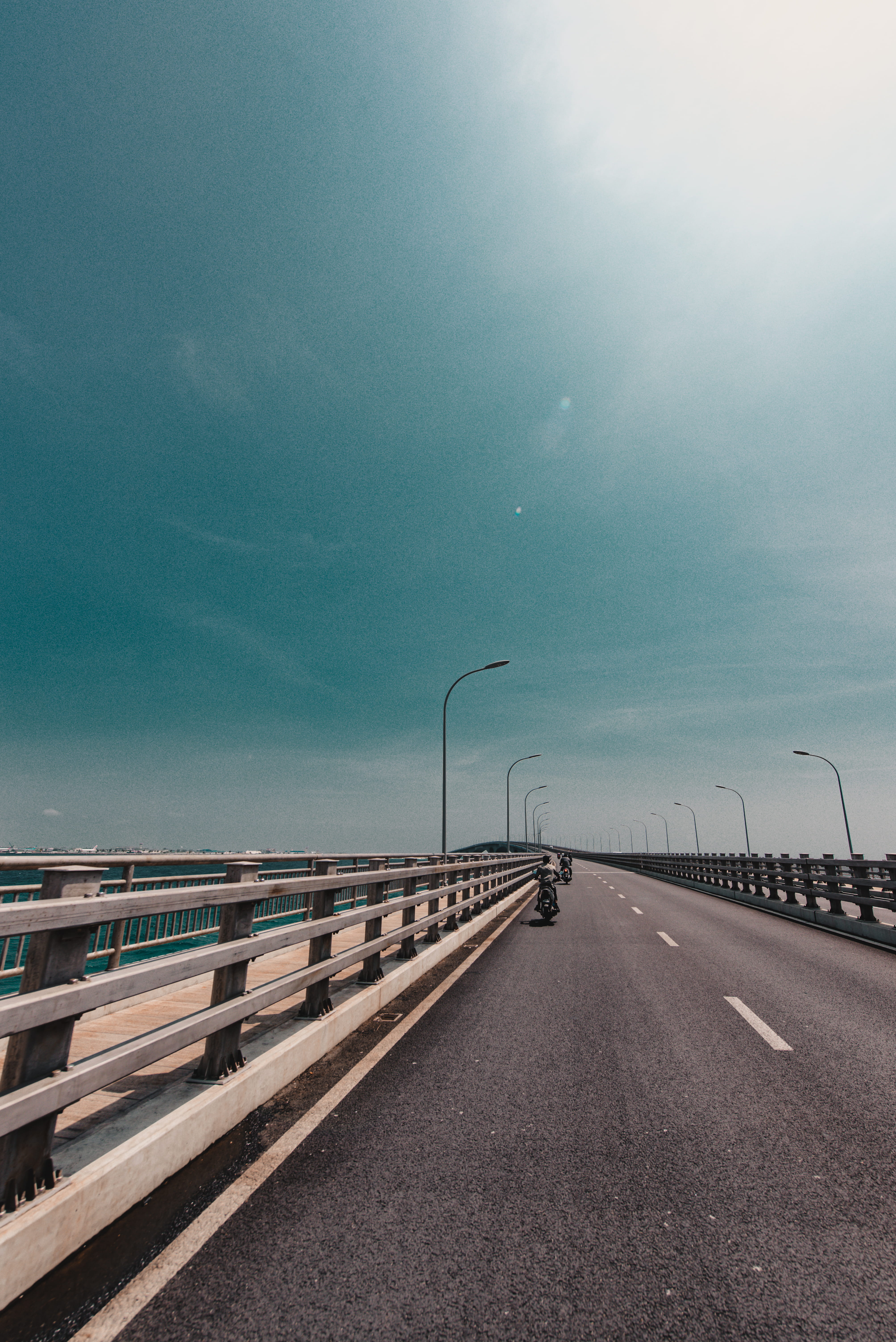 overpass, guard rail, water, banister, human, tarmac, bridge - man made structure, symbol, crash barrier, building, pier, diminishing perspective, vanishing point, Phone HD Wallpaper