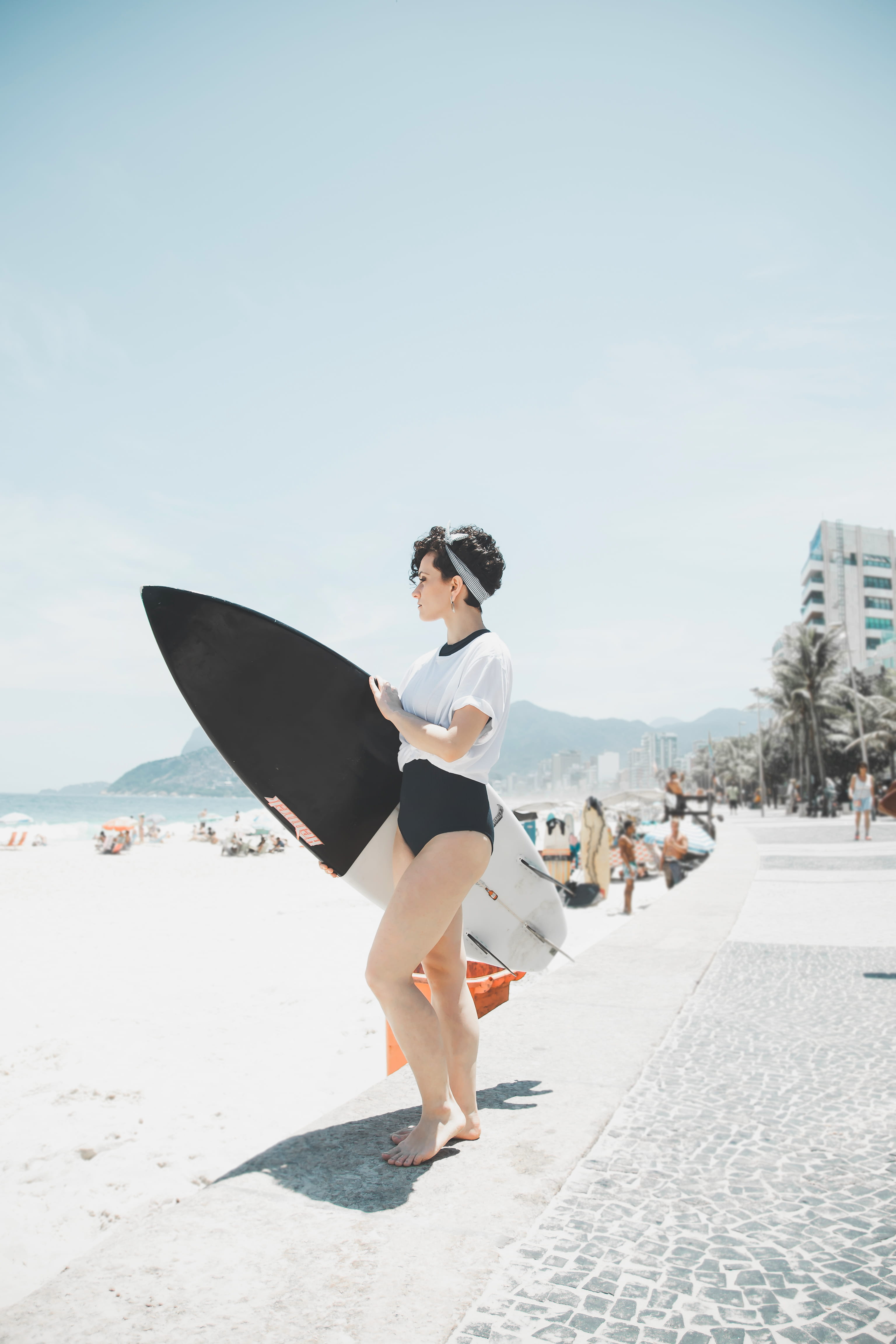 4K, board, land, holding, sky, hairstyle, sunlight, women, full length, day, shirt, surf, focus on foreground, mar, incidental people, one person, riodejaneiro, Phone HD Wallpaper