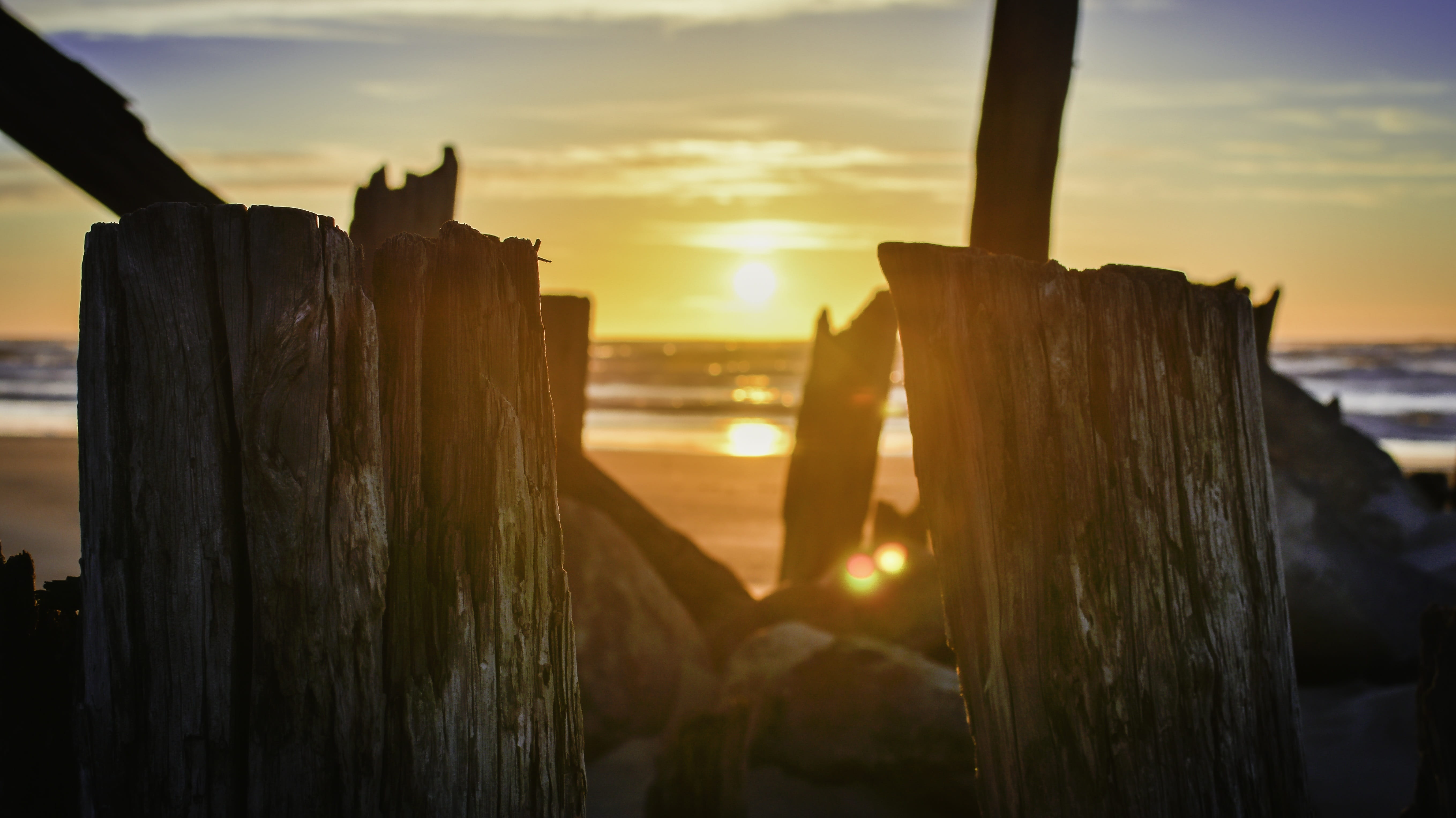 focus on foreground, beach, land, sunset, lens flare, tranquility, sunlight, sea, wood - material, sunset evening, 5K, baltic sea, tranquil scene, sky, HD Wallpaper