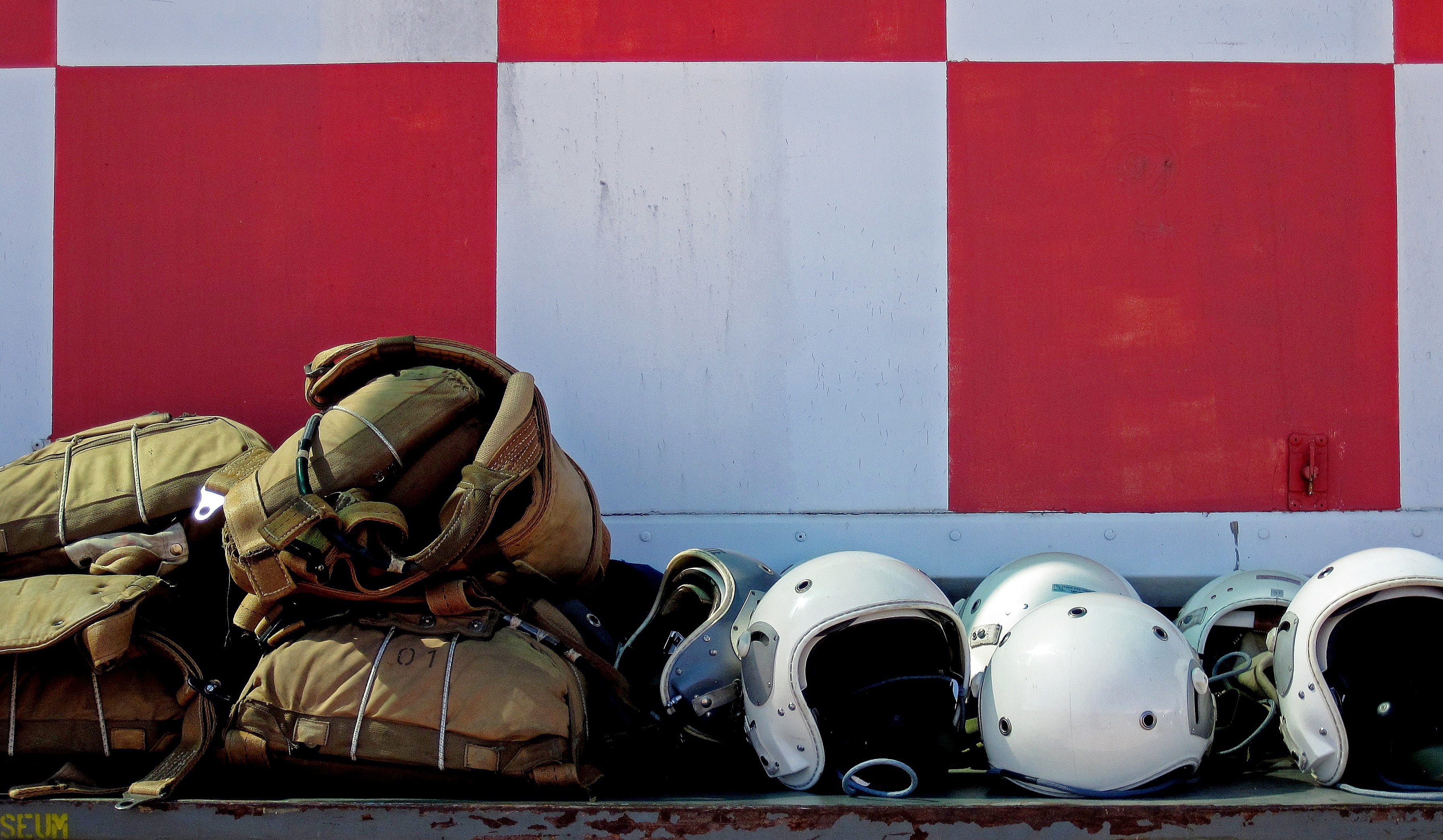 headwear, aviator, Bone, army, military, container wall, checkered, backpack, red, helmet, day, real people, pre-flight, pilot, wall - building feature, HD Wallpaper