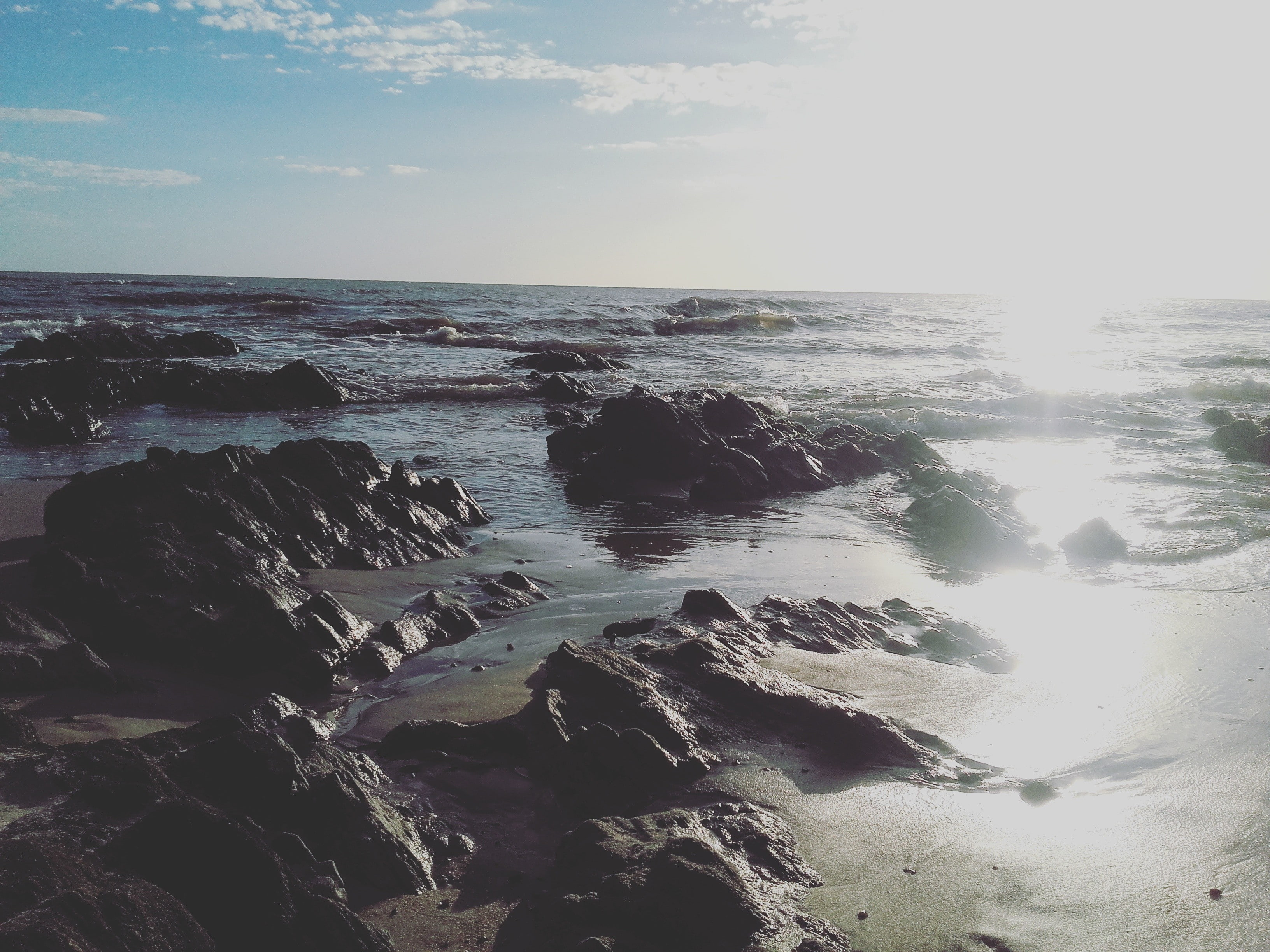 sunlight, nature, 2K, beauty in nature, sky, horizon, rocky coastline, tranquility, idyllic, beach, rock - object, water, rock, horizon over water, solid, HD Wallpaper