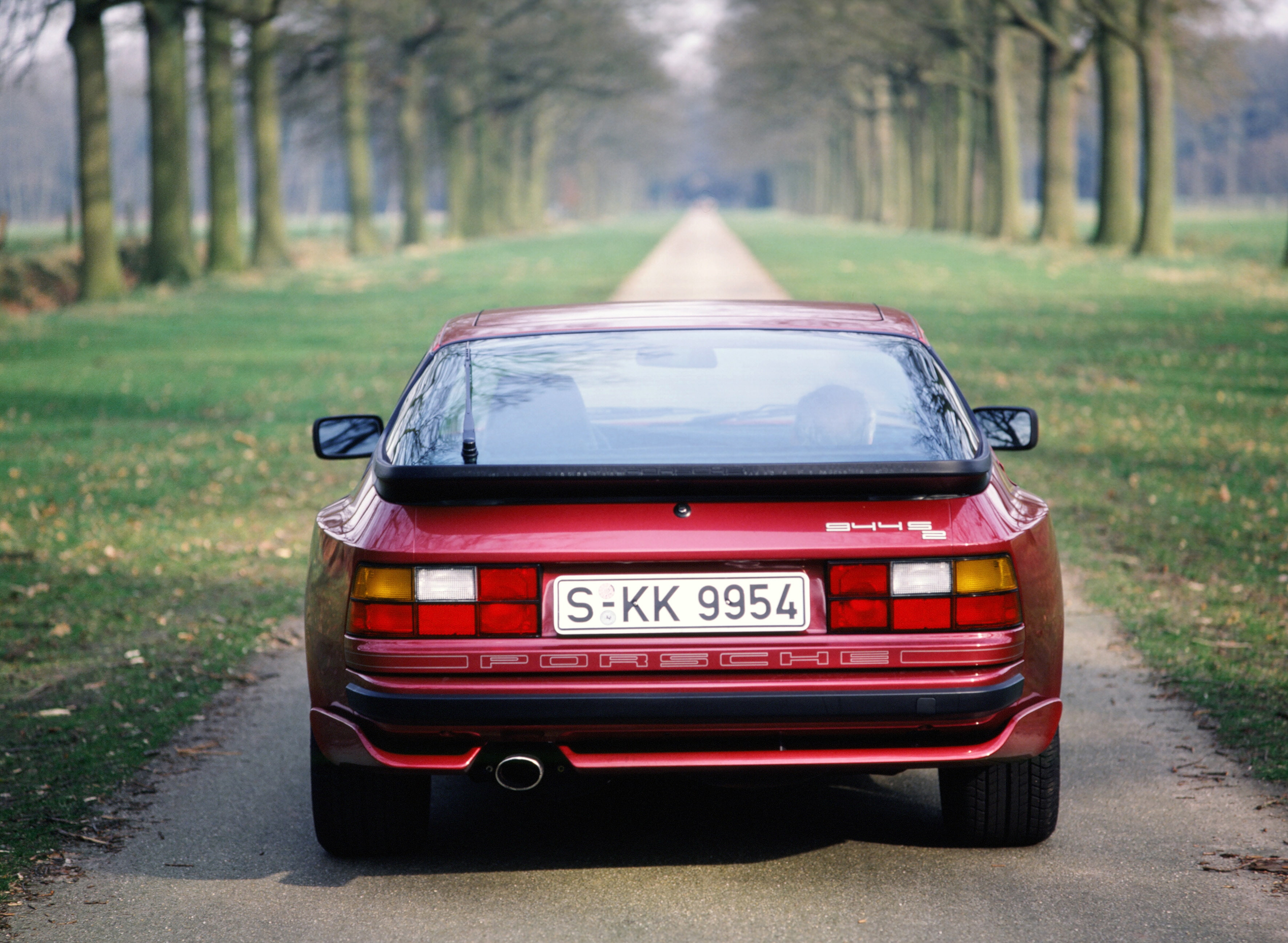 car, day, no people, road, tree, sunlight, 1990, outdoors, plant, red, nature, transportation, 2K, motor vehicle, grass, porsche, land, retro styled, 944, HD Wallpaper