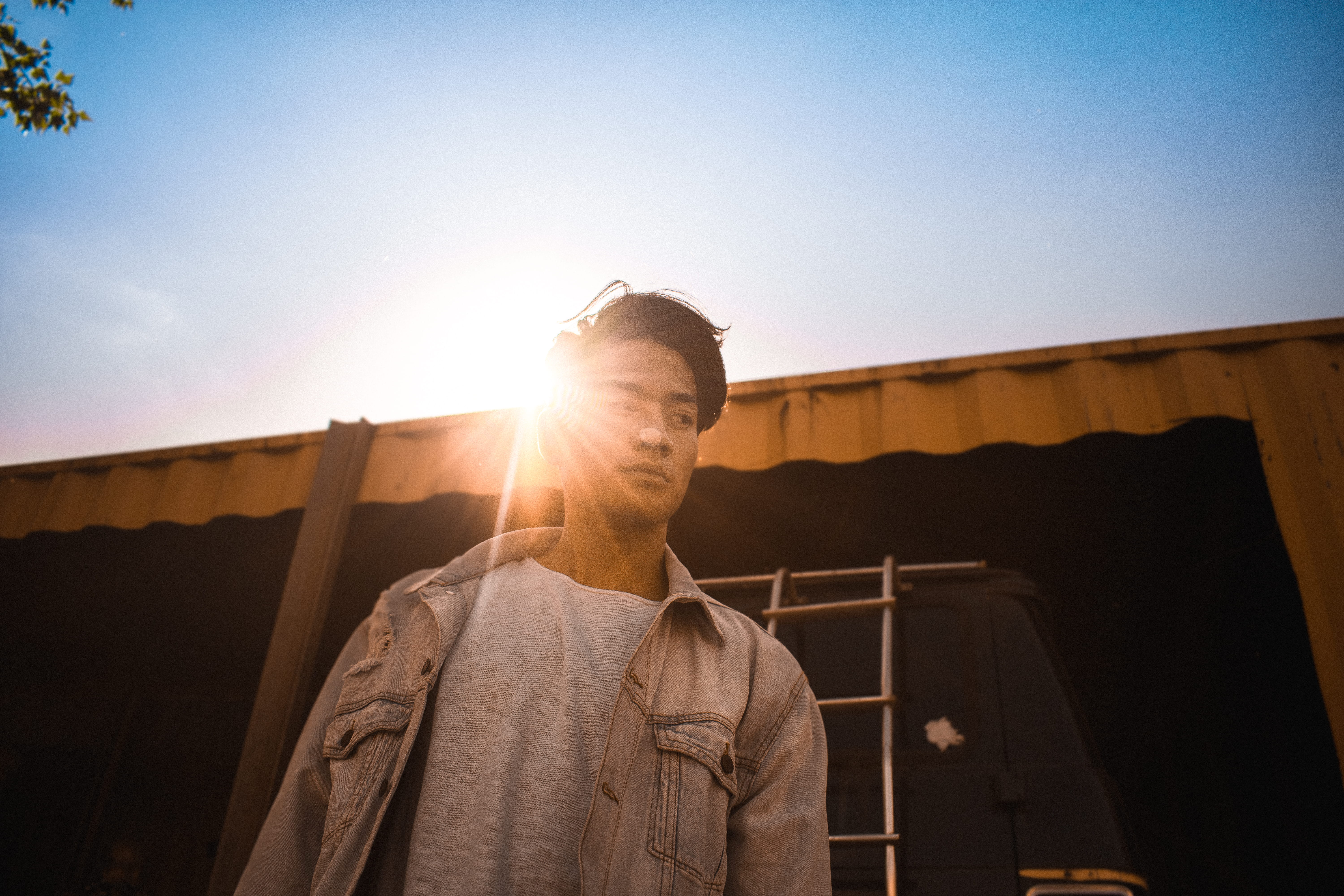 casual clothing, standing, portrait, low angle view, urban, overcoat, face, sky, clothing, sunlight, young adult, sunset, basel, jacket, person, building, HD Wallpaper
