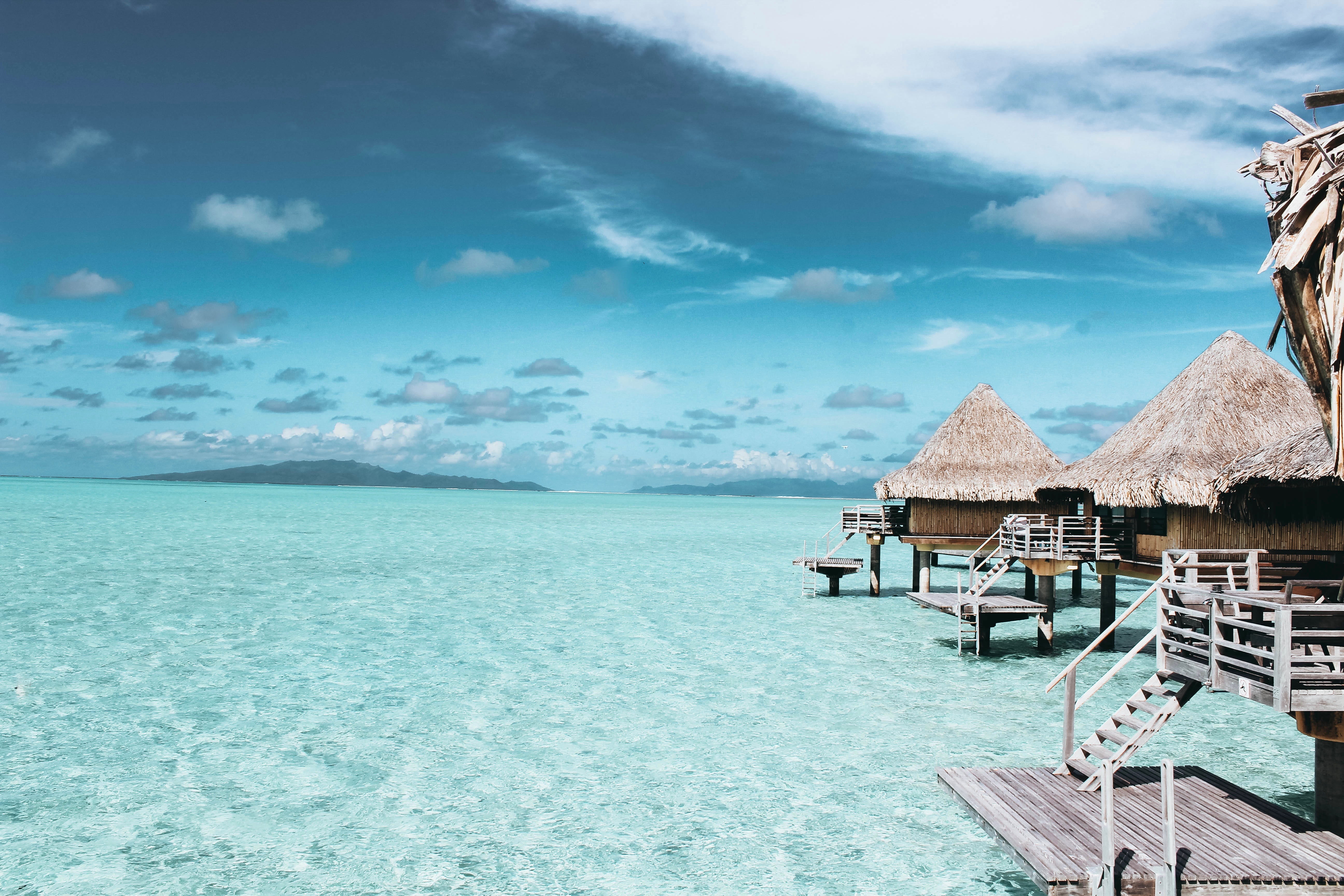 balconies, sea, cloud - sky, ocean, horizon over water, land, day, seashore, resort, thatched roof, chair, sand, cottage, water, wooden, brown, turquoise colored, HD Wallpaper