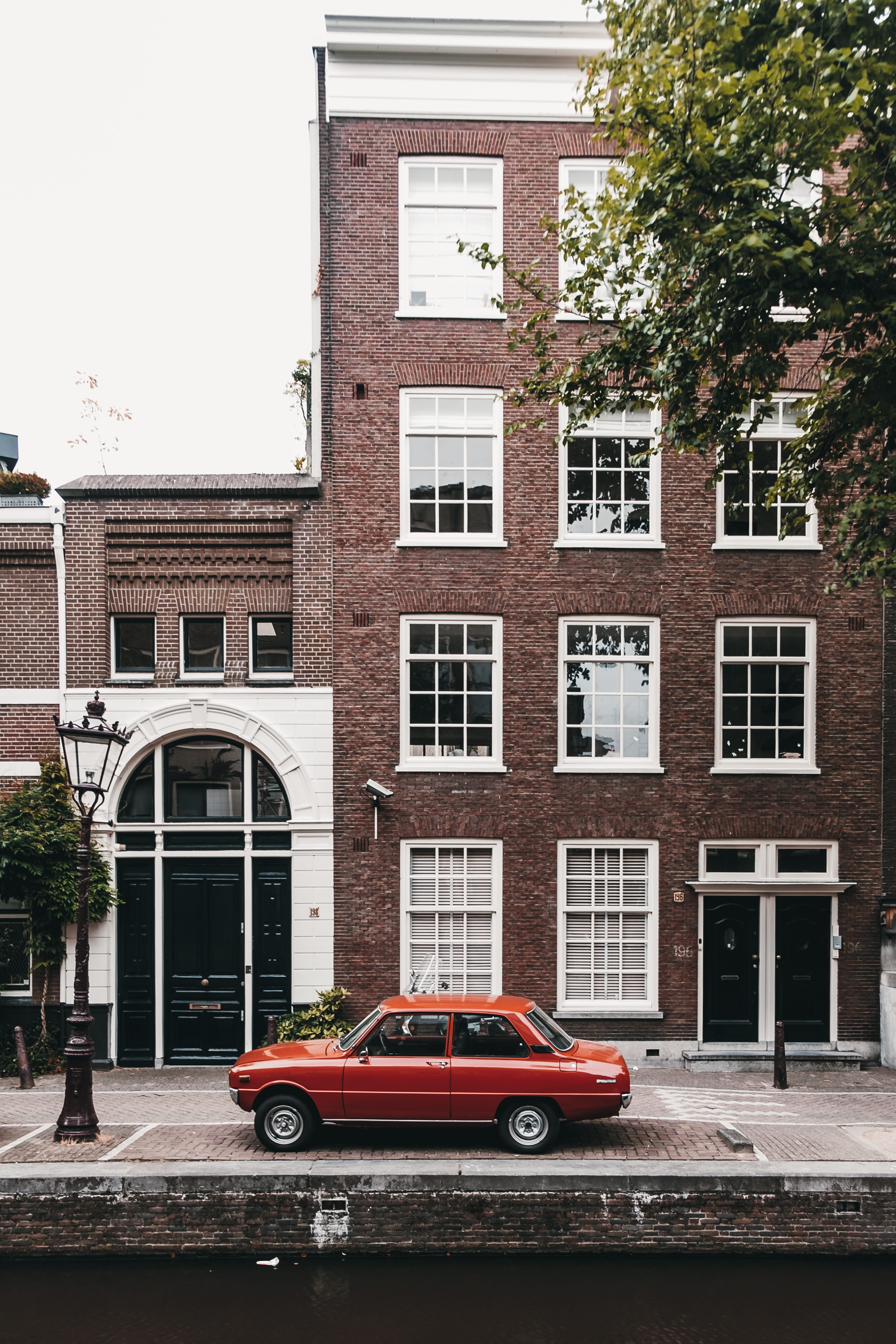 daytime, retro, vintage, amsterdam, facade, built Structure, building Exterior, red, tree, waterway, window, car, retro Styled, mode of Transport, cityscape, Phone HD Wallpaper