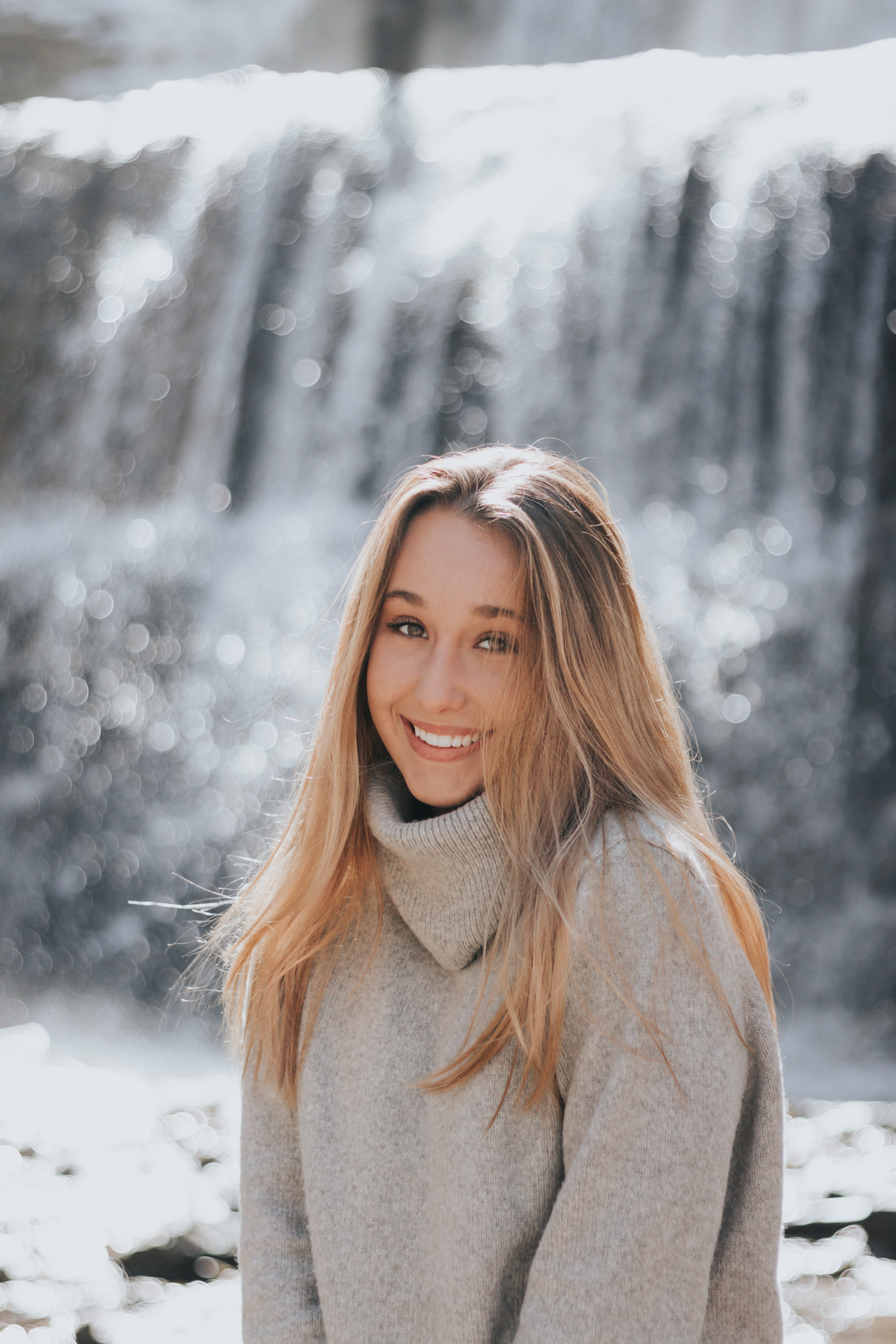 portrait, turtle neck, hairstyle, female, blond hair, blonde hair, beauty, grey, sweater, bokeh, water, beautiful woman, smile, near, warm clothing, looking at camera, Phone HD Wallpaper