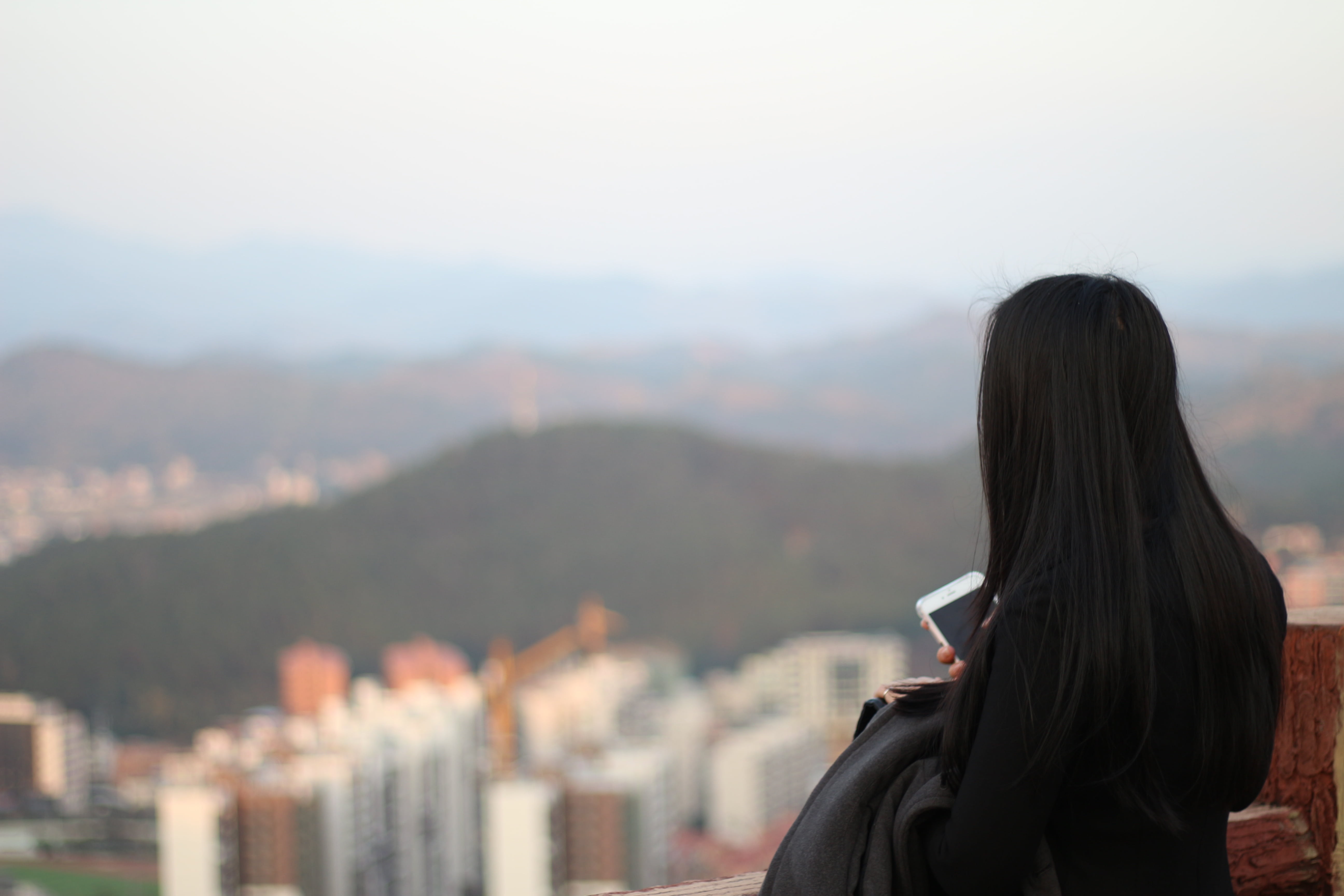 long hair, standing, mountain, cityscape, city, mountains city, rear view, high, headshot, built structure, brunet, contemplation, woman, skyscraper, portrait, HD Wallpaper