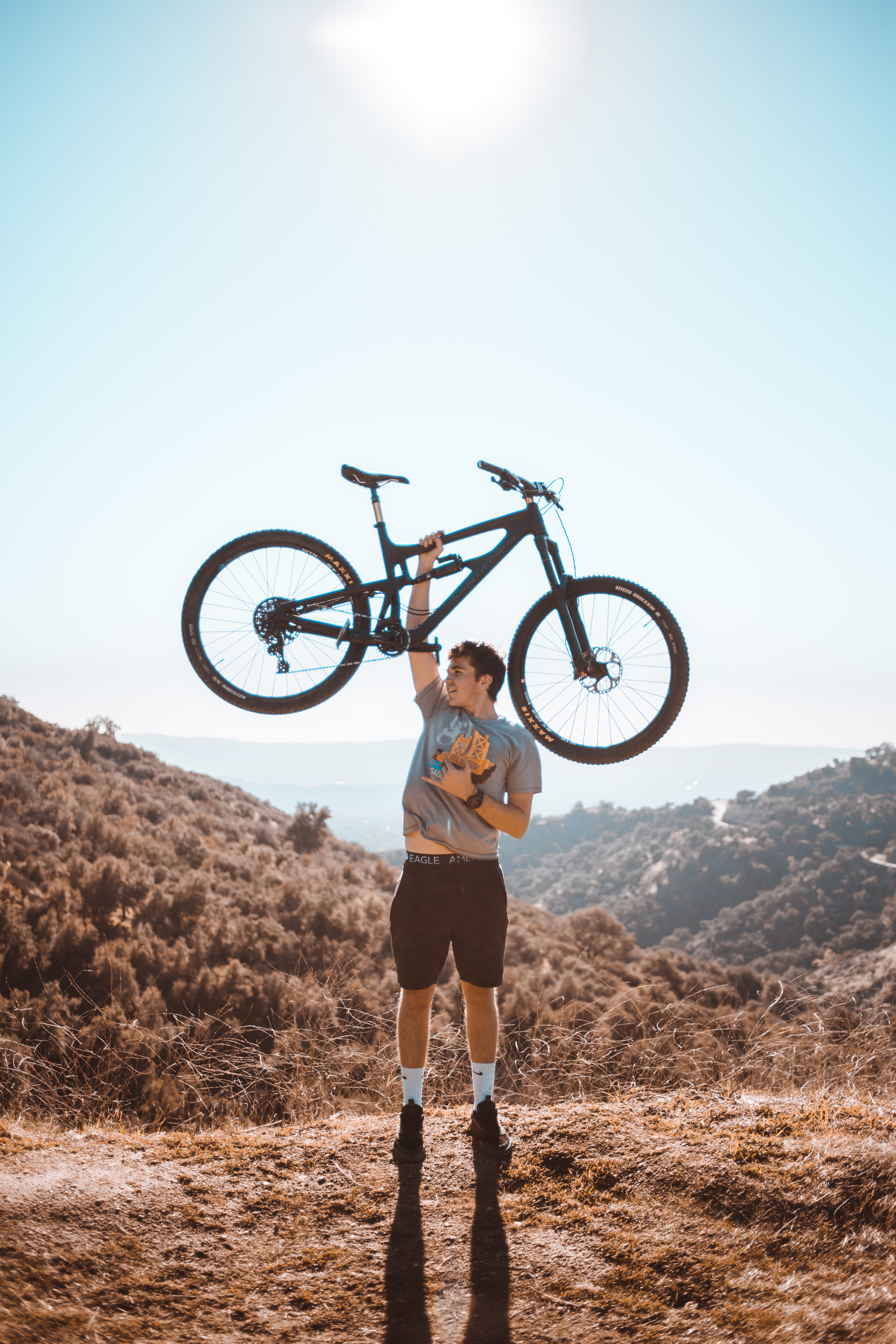 focus, suspension, day, land, bicycle, man, selective, one person, standing, right, sport, lifestyles, sunlight, lifting, bike, nature, clear sky, full length, Phone HD Wallpaper