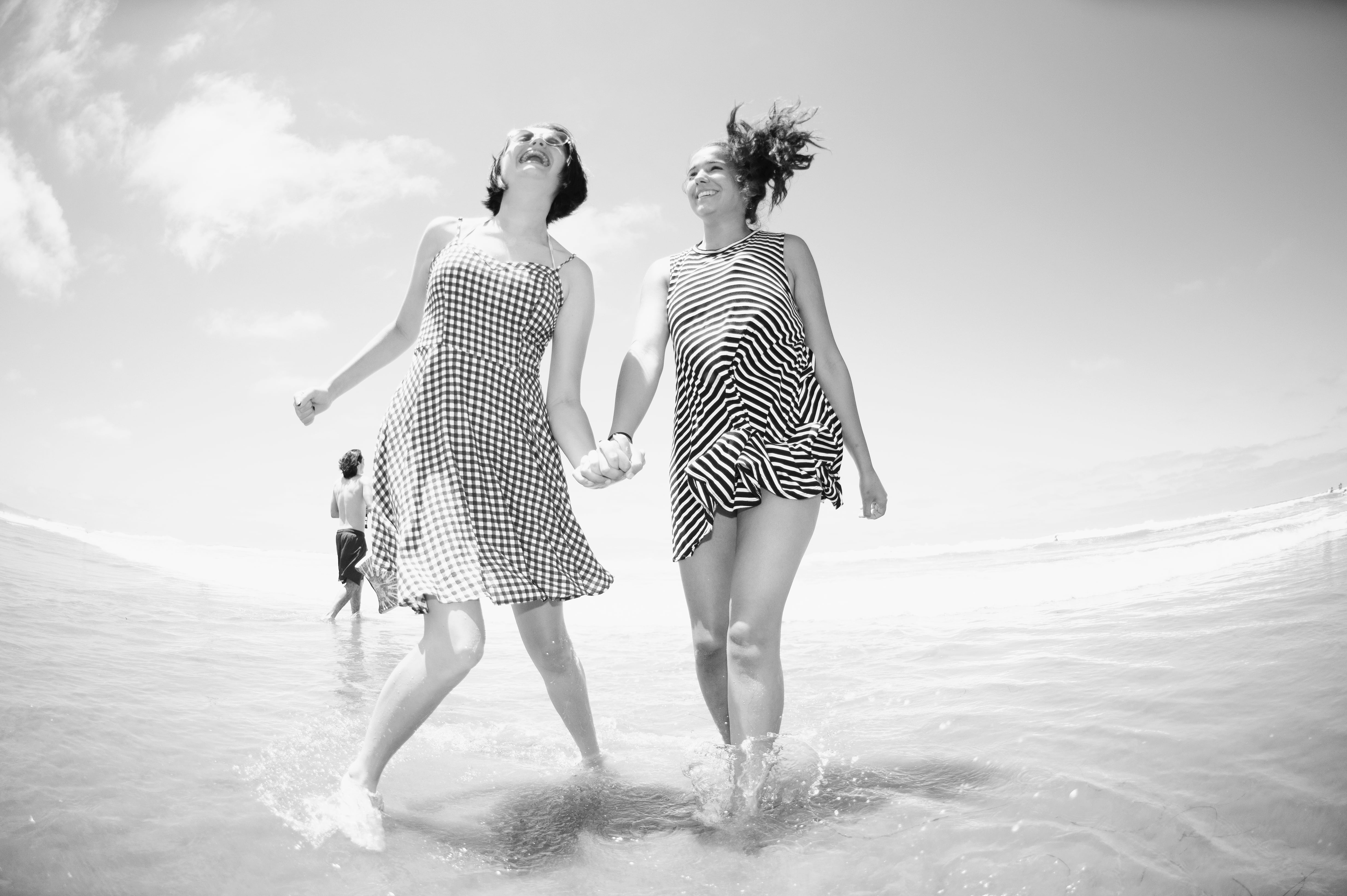 swimwear, seashore, women, land, vacations, dress, grayscale, clouds, splash, black and white, full length, happy, walking, beach, happiness, outdoors, HD Wallpaper