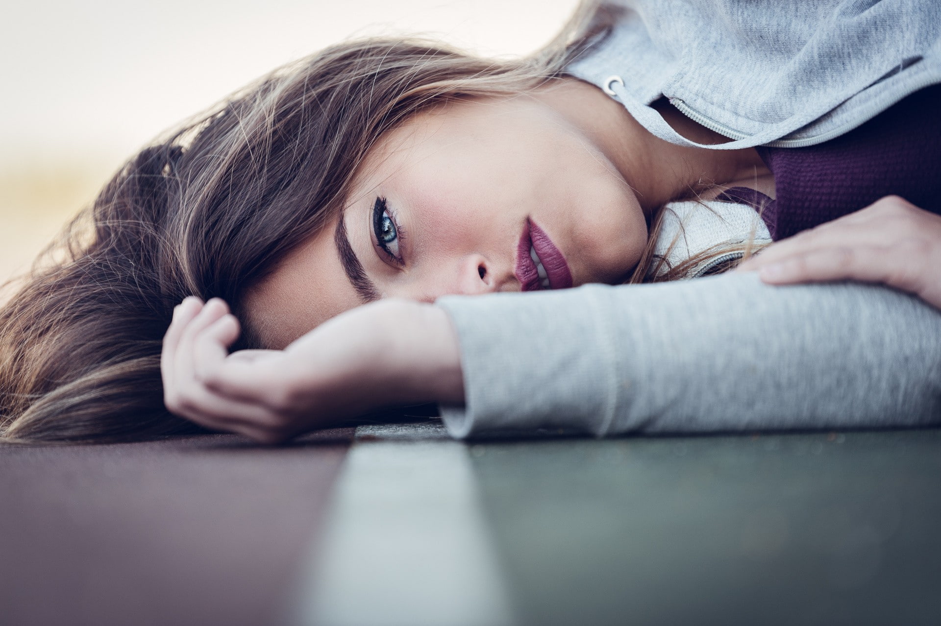 model, women, brunette, blue eyes, 1080P, face, red lipstick, portrait, lying down, road, HD Wallpaper
