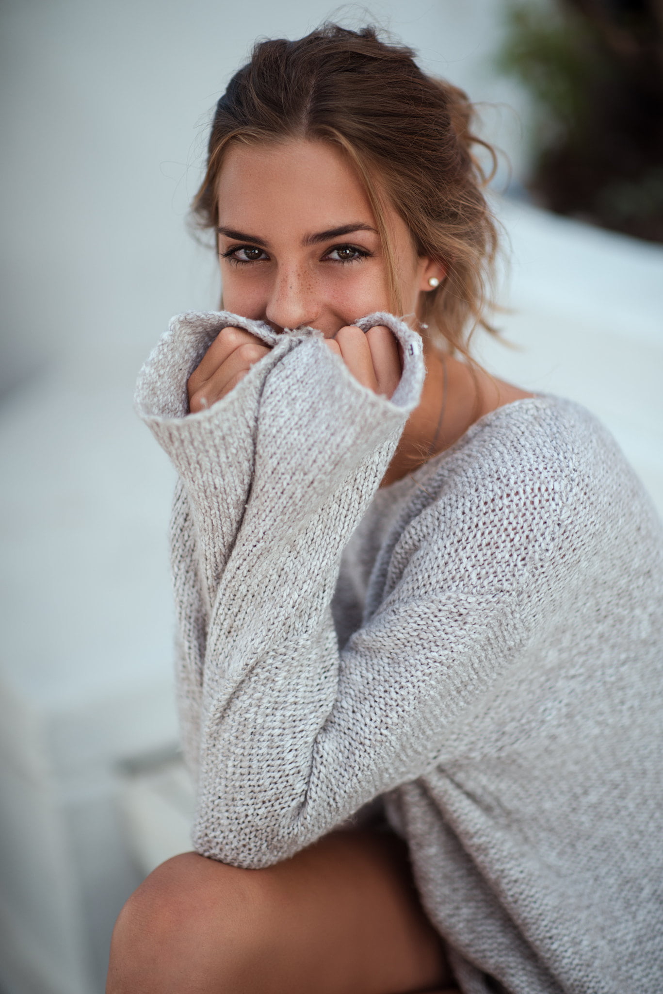 brunette, women, covered face, model, looking at viewer, covering face, freckles, pearl earrings, 1080P, grey sweater, sweater, vertical, 500px, Phone HD Wallpaper