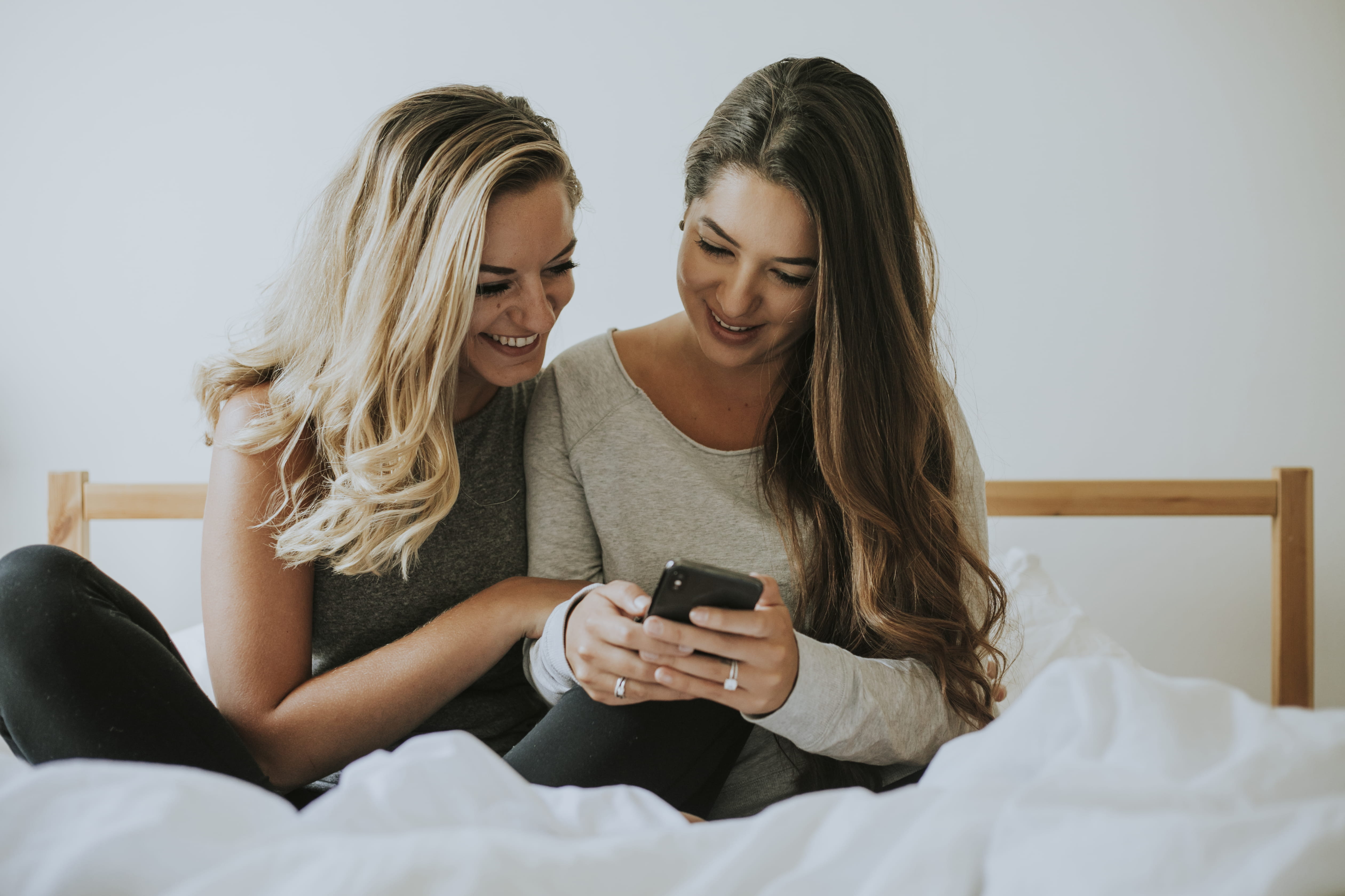 blanket, real people, adult, lifestyles, together, bed, holding, leisure activity, black, blond hair, girls, phone, looking, smartphone, togetherness, female, HD Wallpaper
