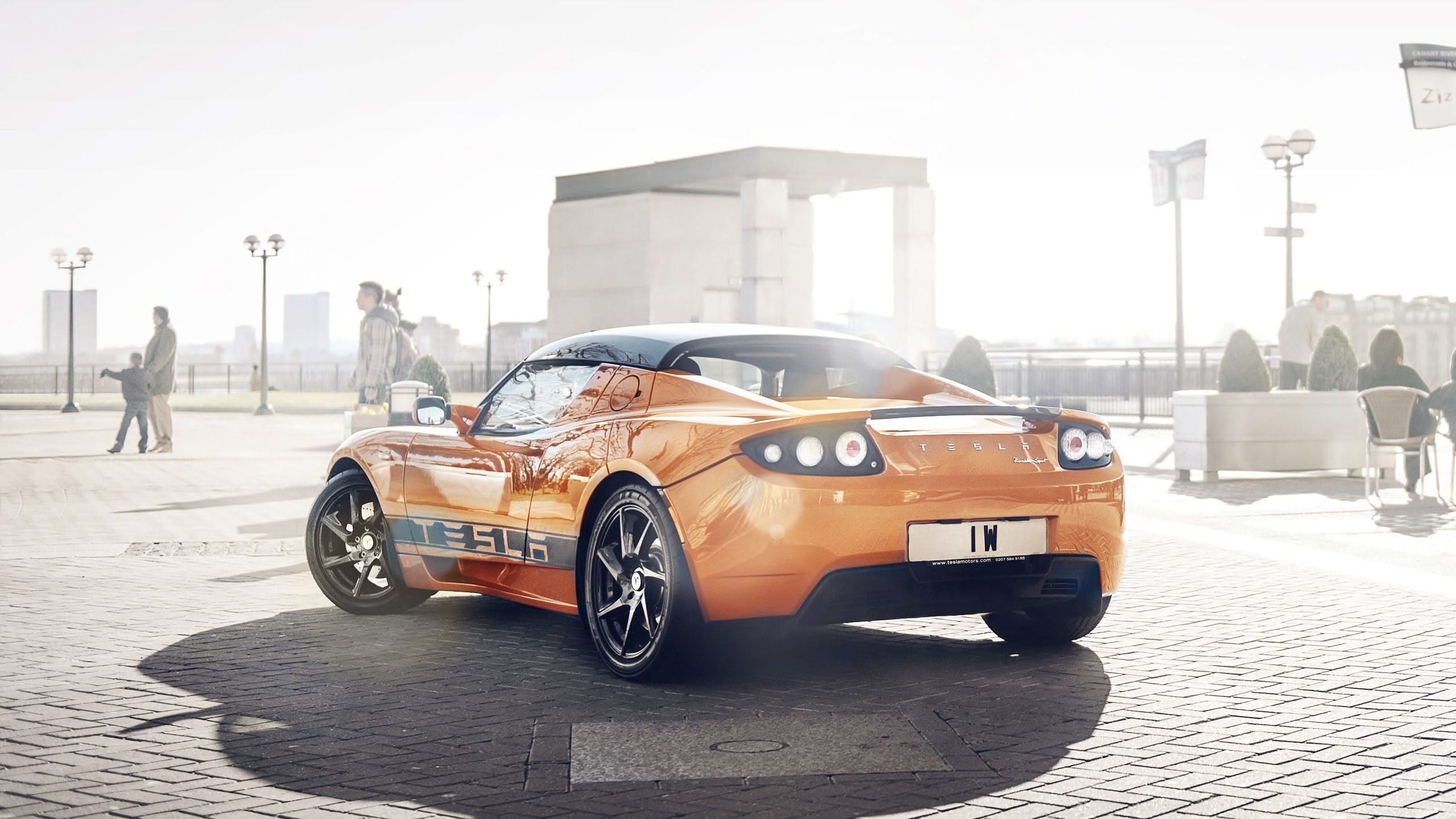 car, tesla roadster, street, sunlight, land vehicle, nature, city, outdoors, day, wealth, road, transportation, incidental people, 2K, building exterior, HD Wallpaper