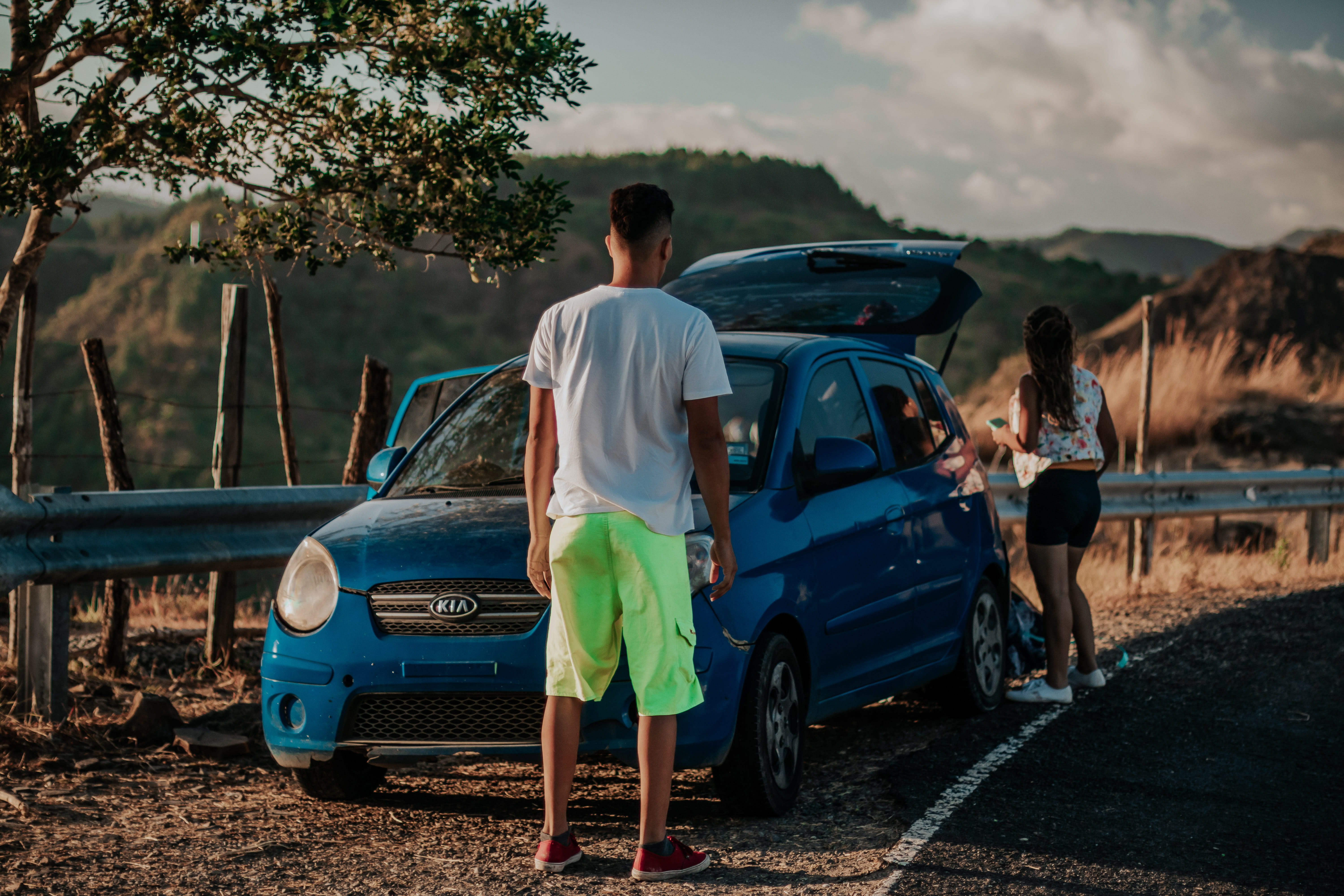 asphalt, daytime, KIA, casual clothing, men, landscape, front, mountain, automobile, lifestyles, land vehicle, woman, moment, sky, 5K, vehicle, togetherness, HD Wallpaper
