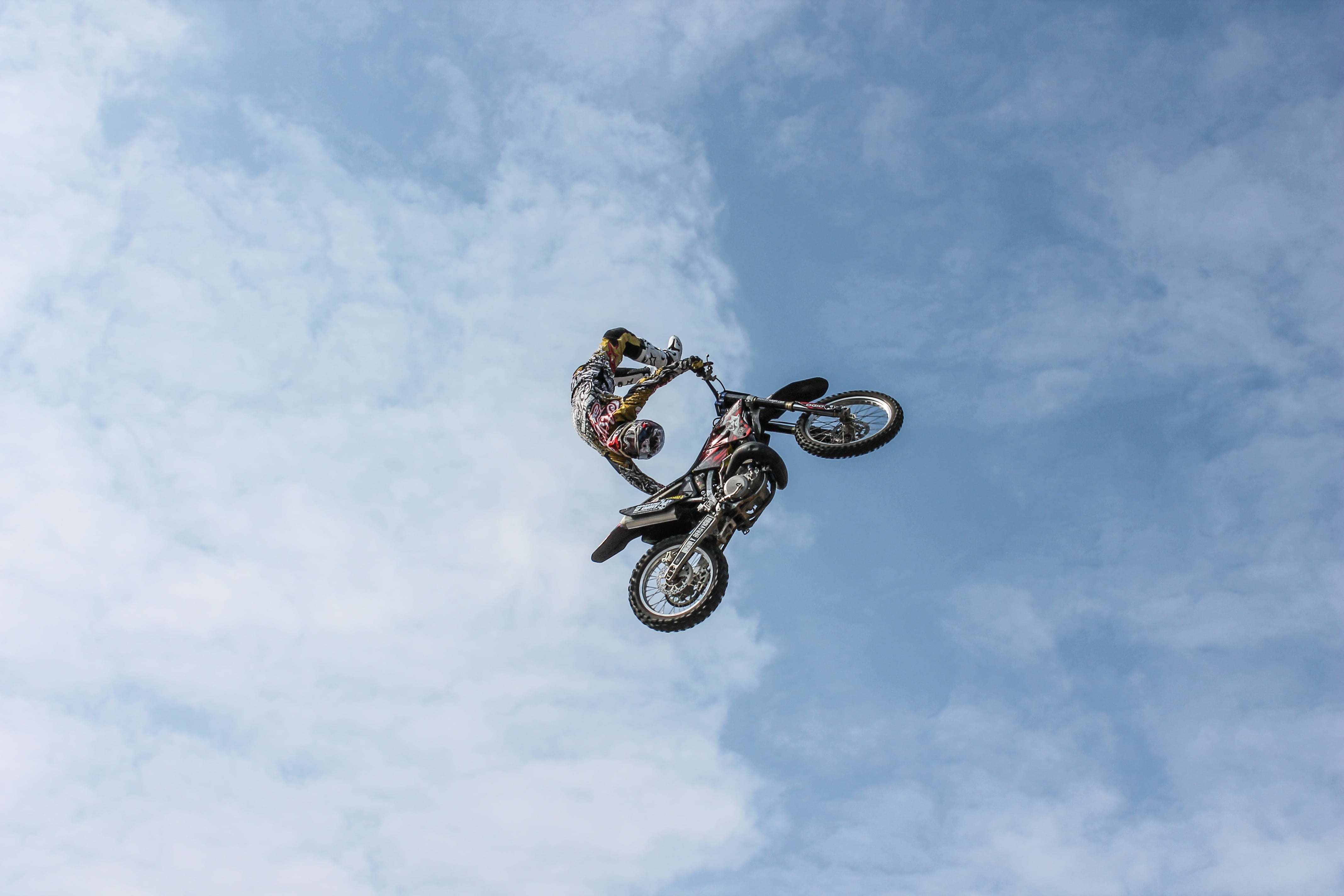 person, sign, biker, dirt, ride, headwear, crash helmet, jump, outdoors, man, skill, communication, jumping, motocross, transportation, action, low angle view, HD Wallpaper