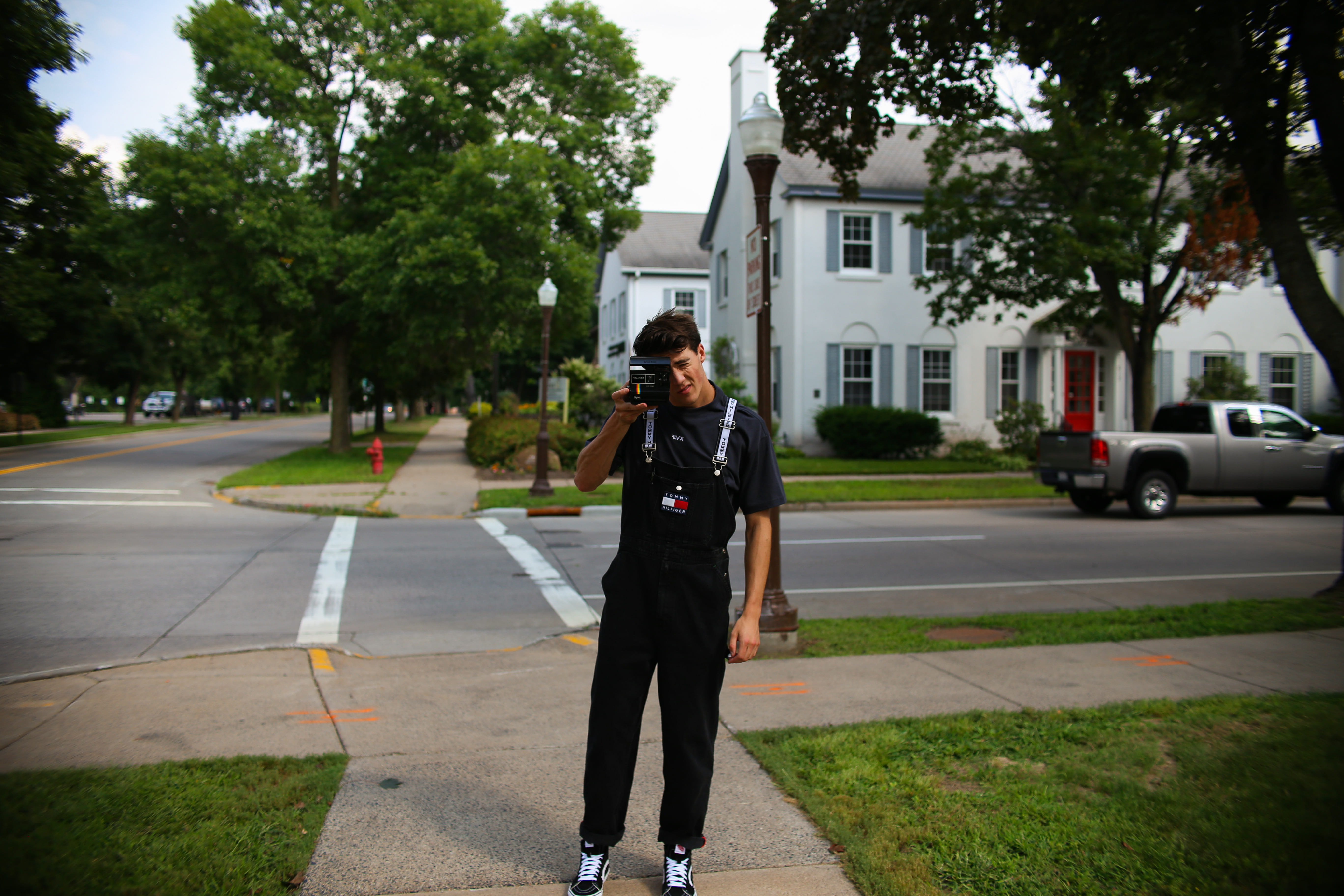 lamp post, holding, real people, corner, day, one person, polaroid, street, standing, mode of transportation, human, uniform, leisure activity, 5K, house, HD Wallpaper