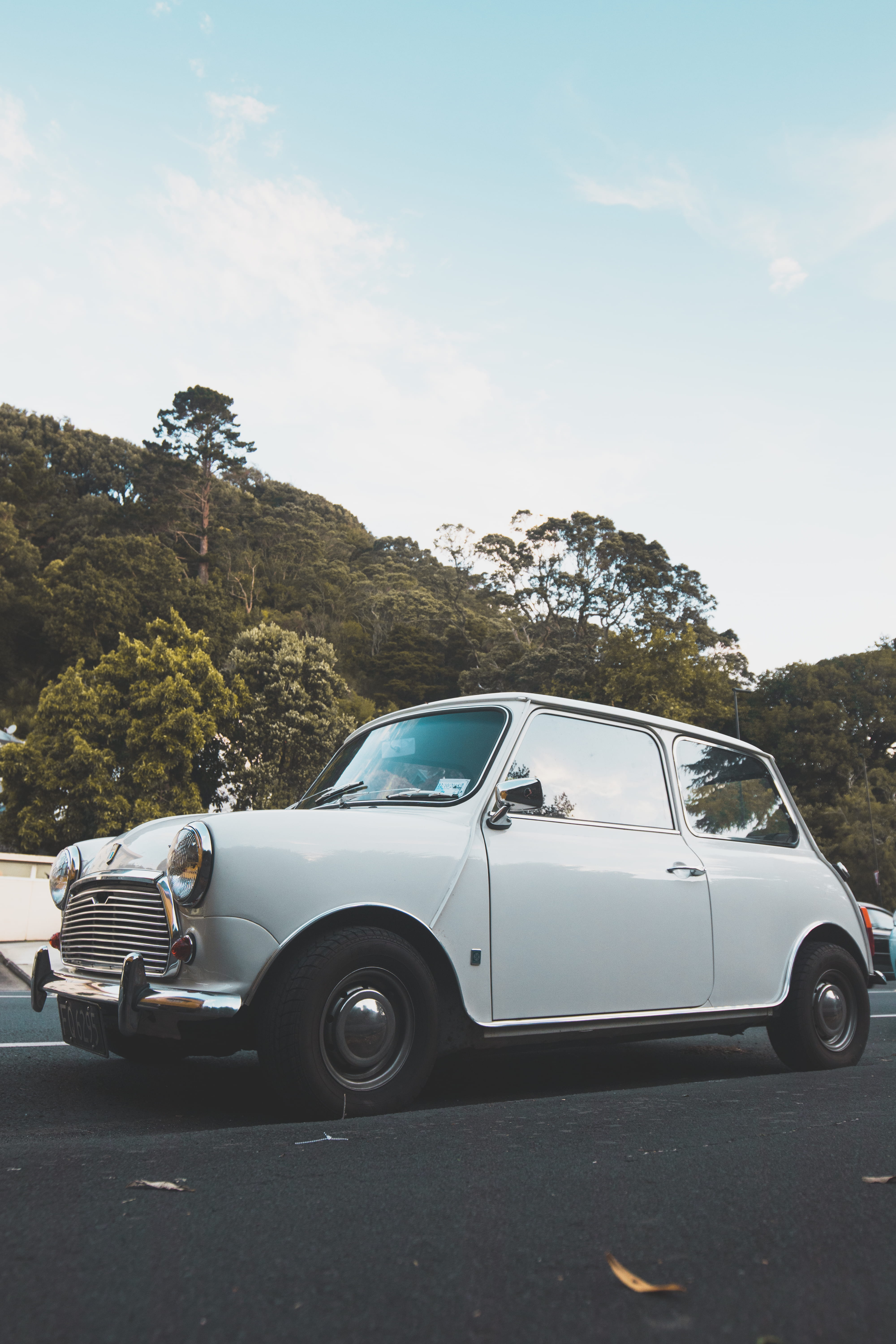 motor vehicle, sunlight, mini, plant, daytime, day, stationary, transportation, reflection, no people, 5K, classic, forest, road, city, nature, sky, chill, Phone HD Wallpaper