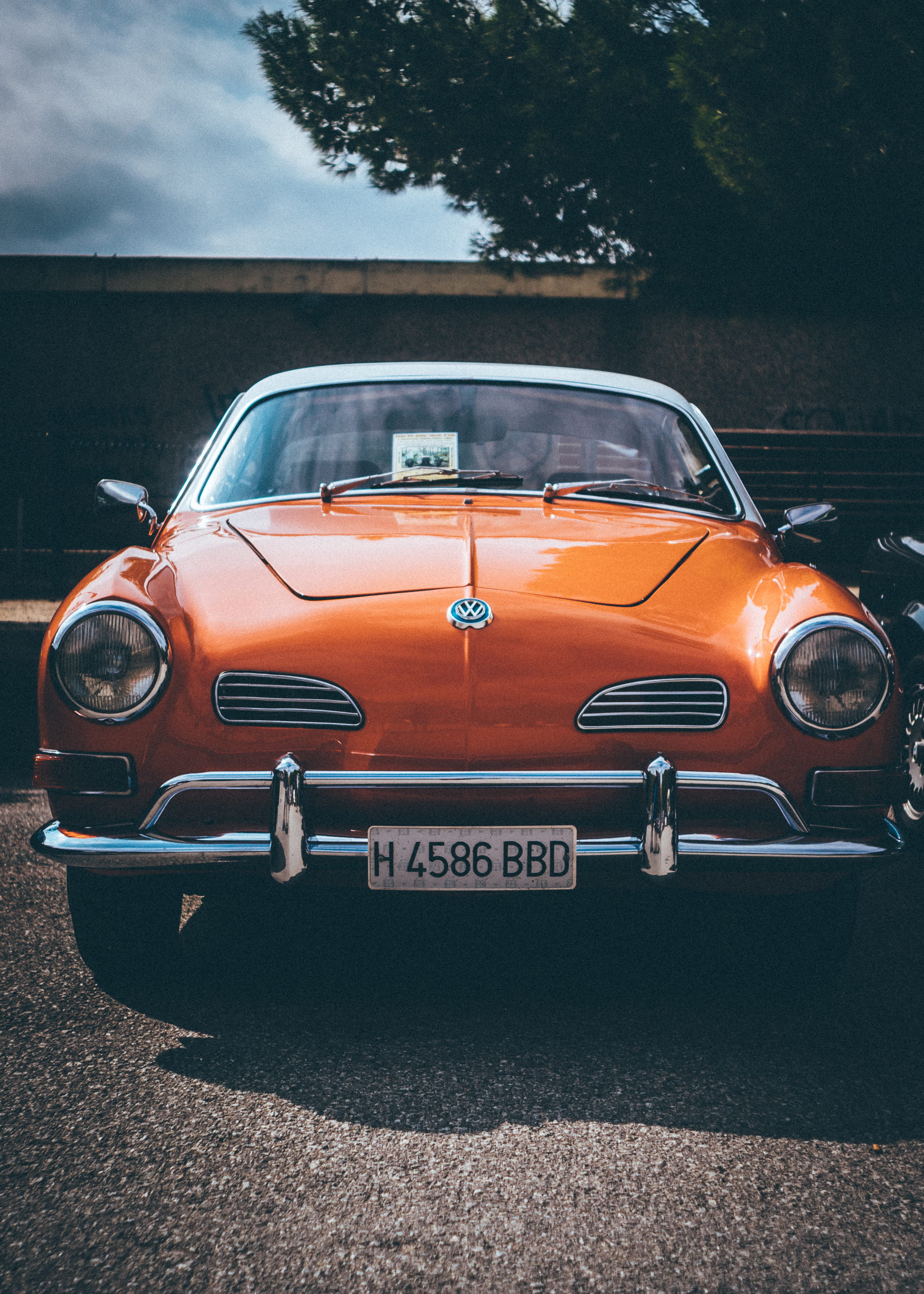 land vehicle, orange, parked, plant, machine, car, sports car, front, collectible, motor, volks wagon, sunlight, text, road, jaguar car, vw, engine, outdoors, Phone HD Wallpaper