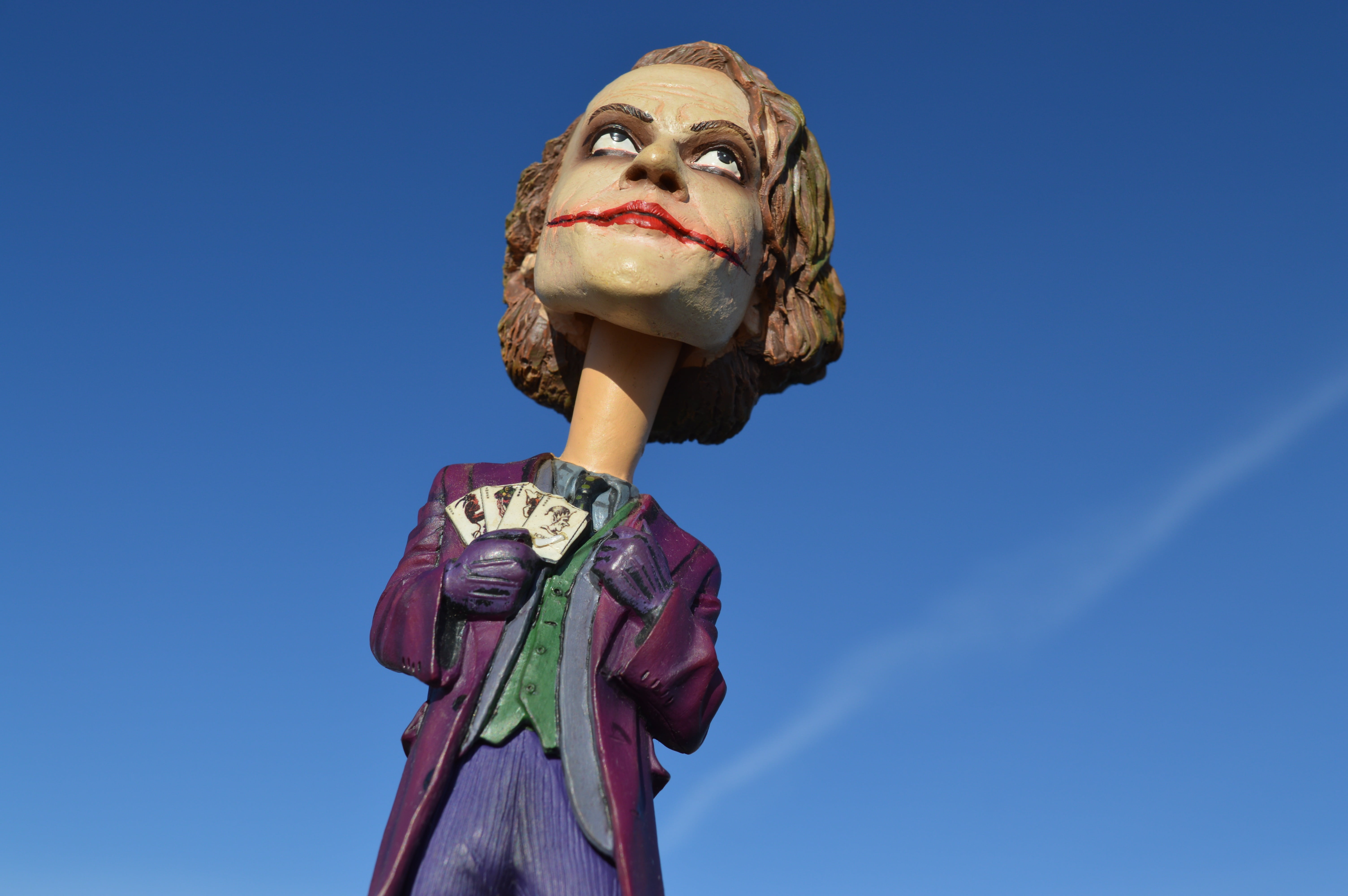 young adult, holding, superhero, day, action figure, comics, 5K, blue sky, clear sky, low angle view, portrait, sculpture, sky, joker, looking at camera, HD Wallpaper