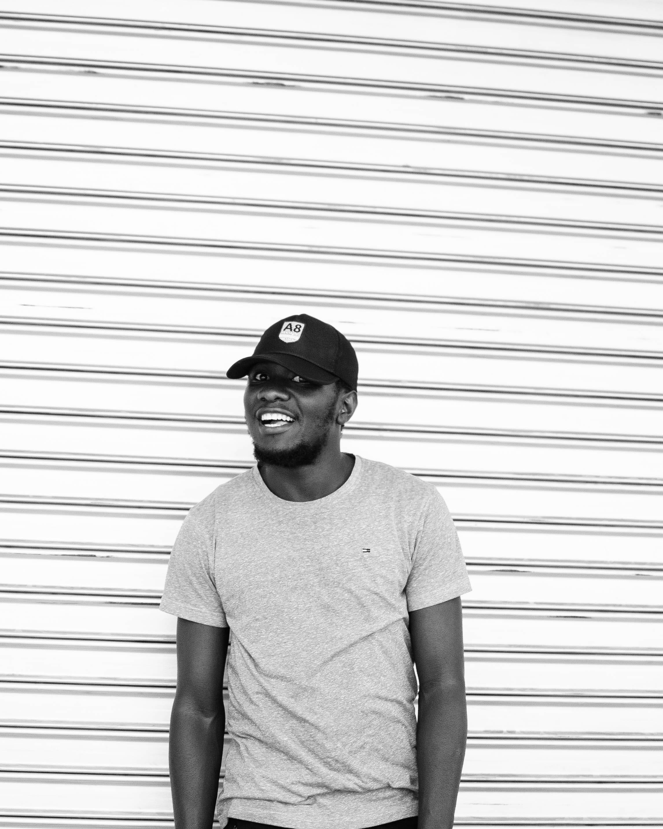 real people, wall - building feature, person, boy, cap, t-shirt, adult, lifestyles, waist up, male, facial hair, smiling, model, young adult, smile, iron, Phone HD Wallpaper