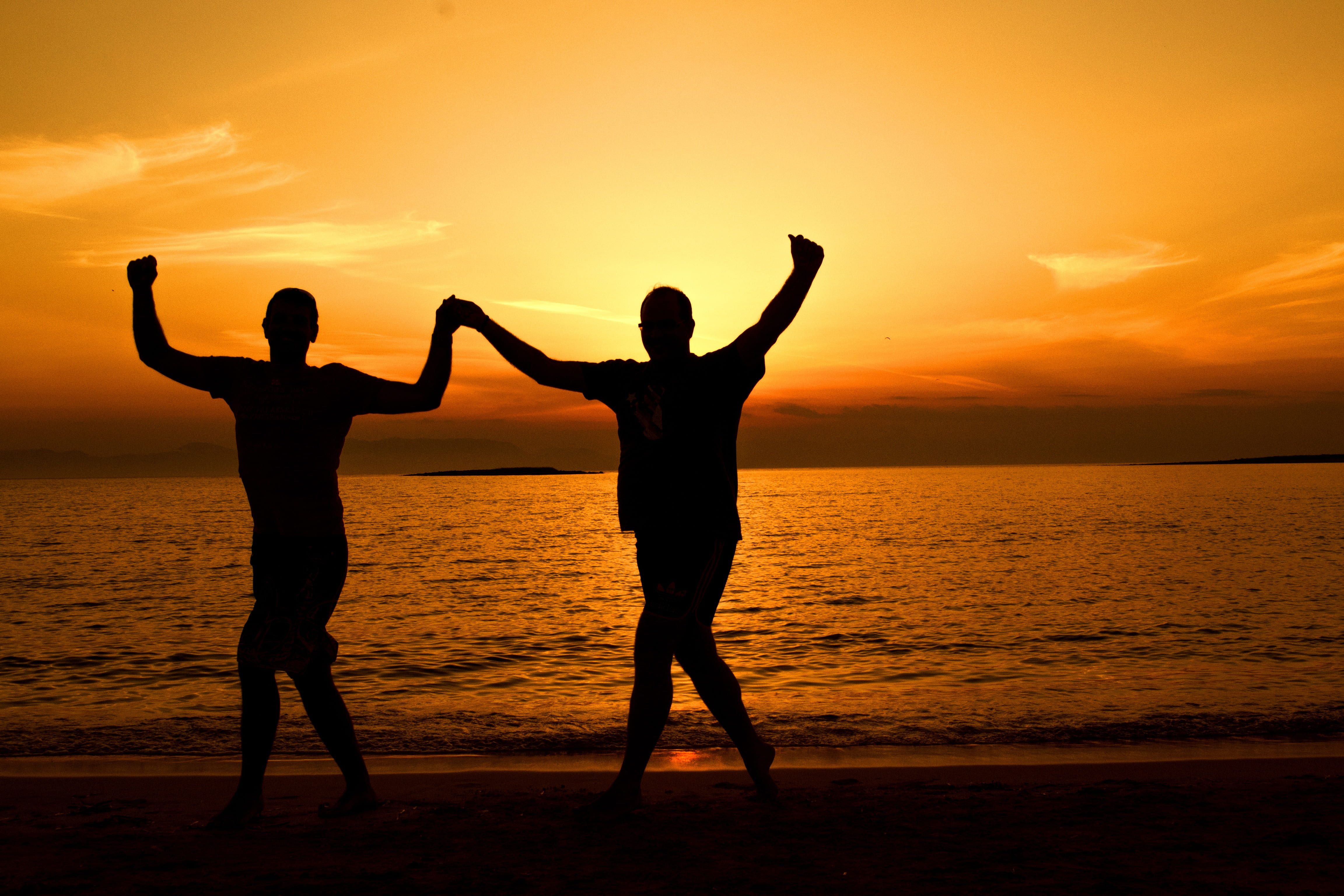 human arm, beauty in nature, fun, adult, backlit, standing, sea, dusk, man, people, sunrise, travel, dance, human limb, enjoyment, holding hands, happiness, HD Wallpaper