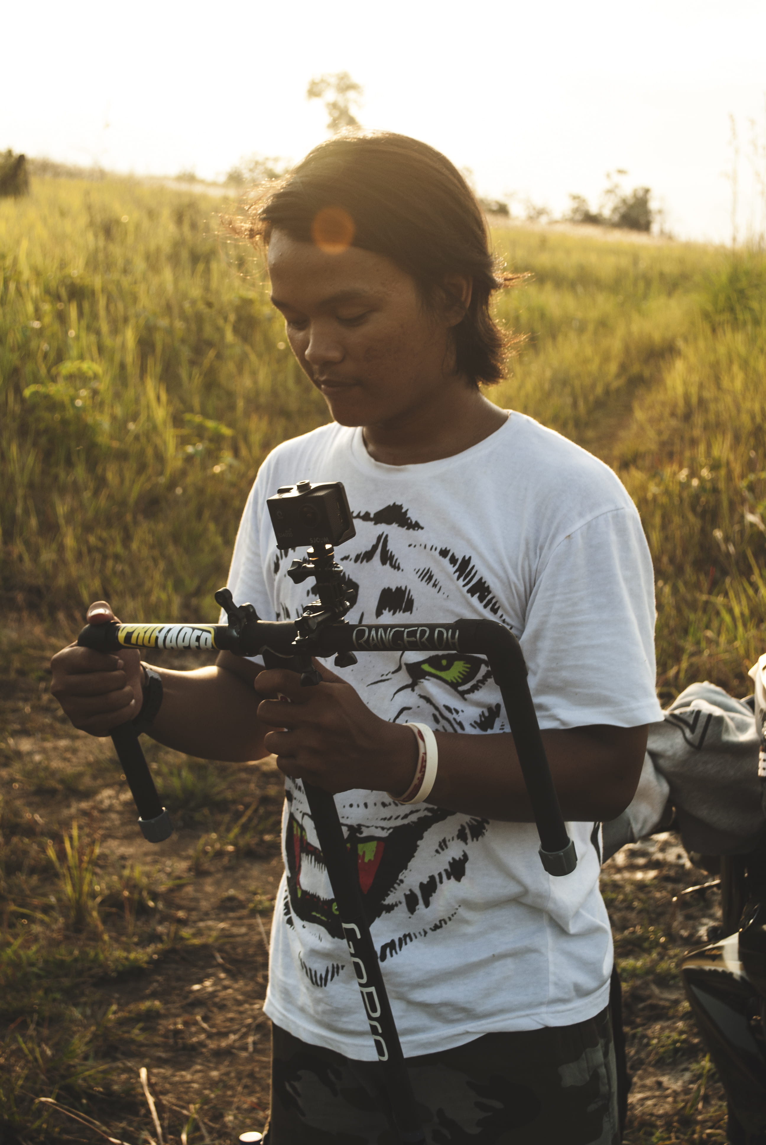 real people, man, go pro, day, holding, looking, young adult, gadgets, camera, one person, black, field, 4K, land, focus on foreground, leisure activity, Phone HD Wallpaper
