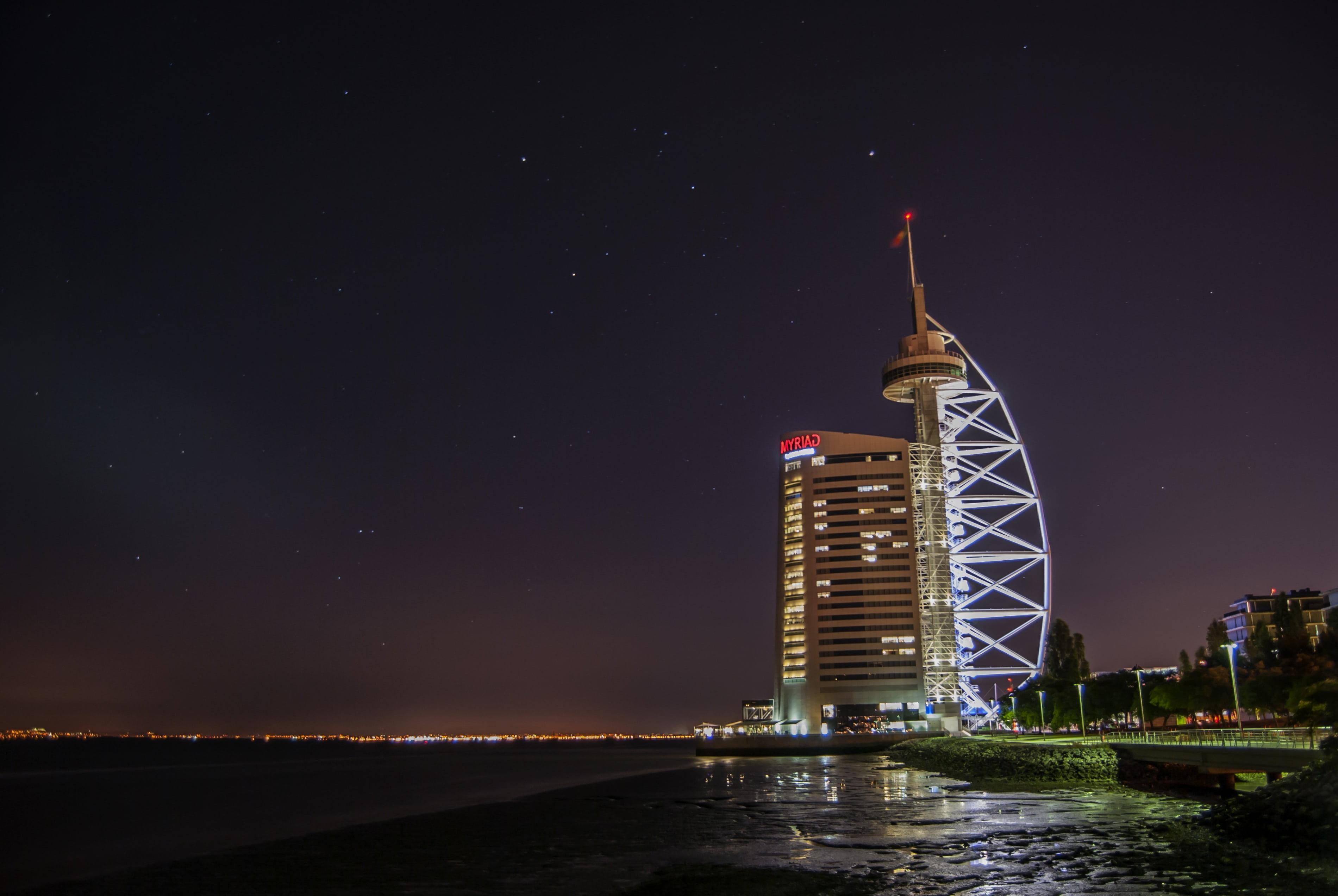 white, 2K, europe, tejo, tall - high, beside, night, building, travel destinations, no people, illuminated, astronomy, sky, rio, tagus river, outdoors, HD Wallpaper