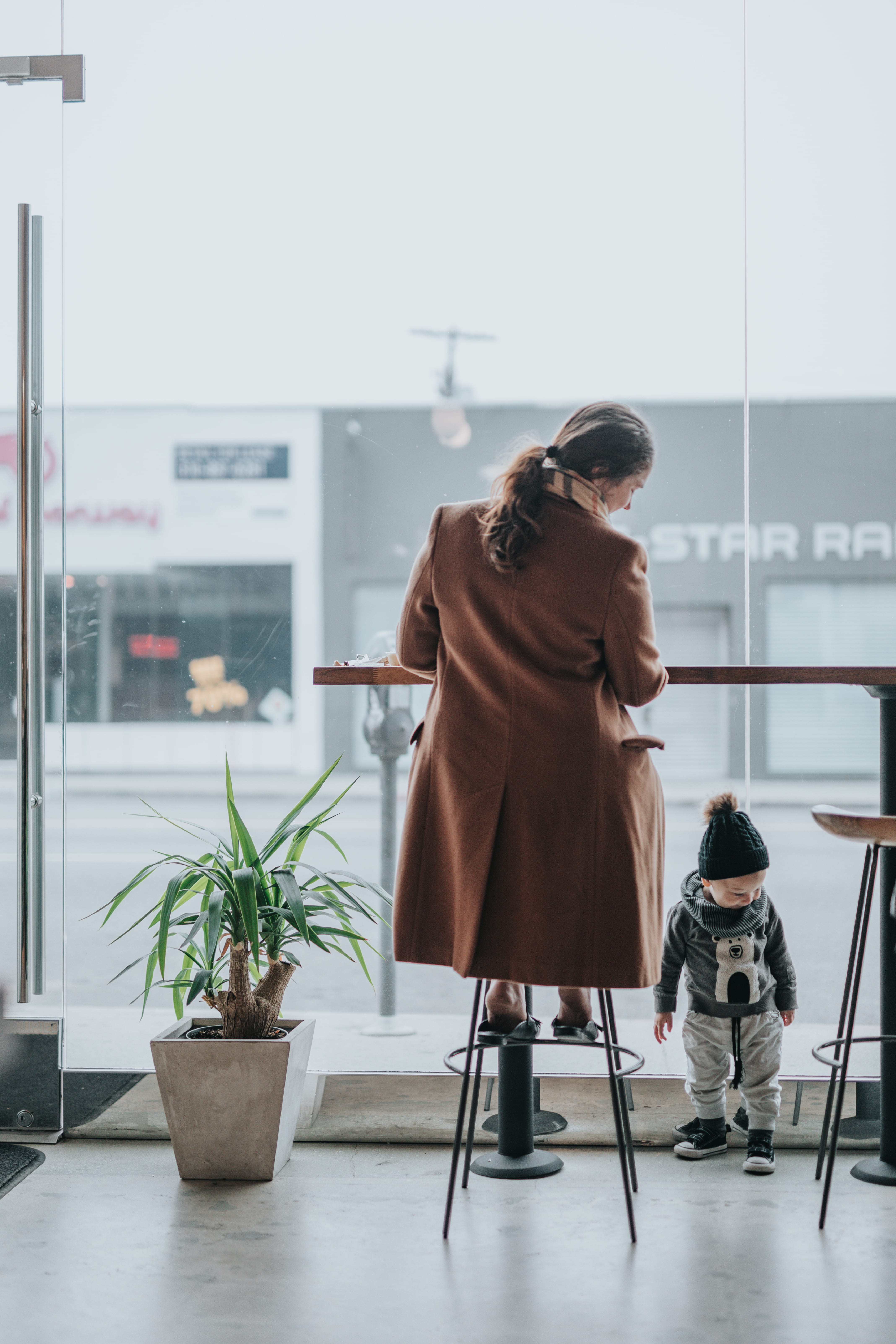 brown, casual clothing, mommy, child, person, looking, indoors, window, women, stool, espresso, 5K, mom, bar, standing, rear view, son, females, adult, Phone HD Wallpaper