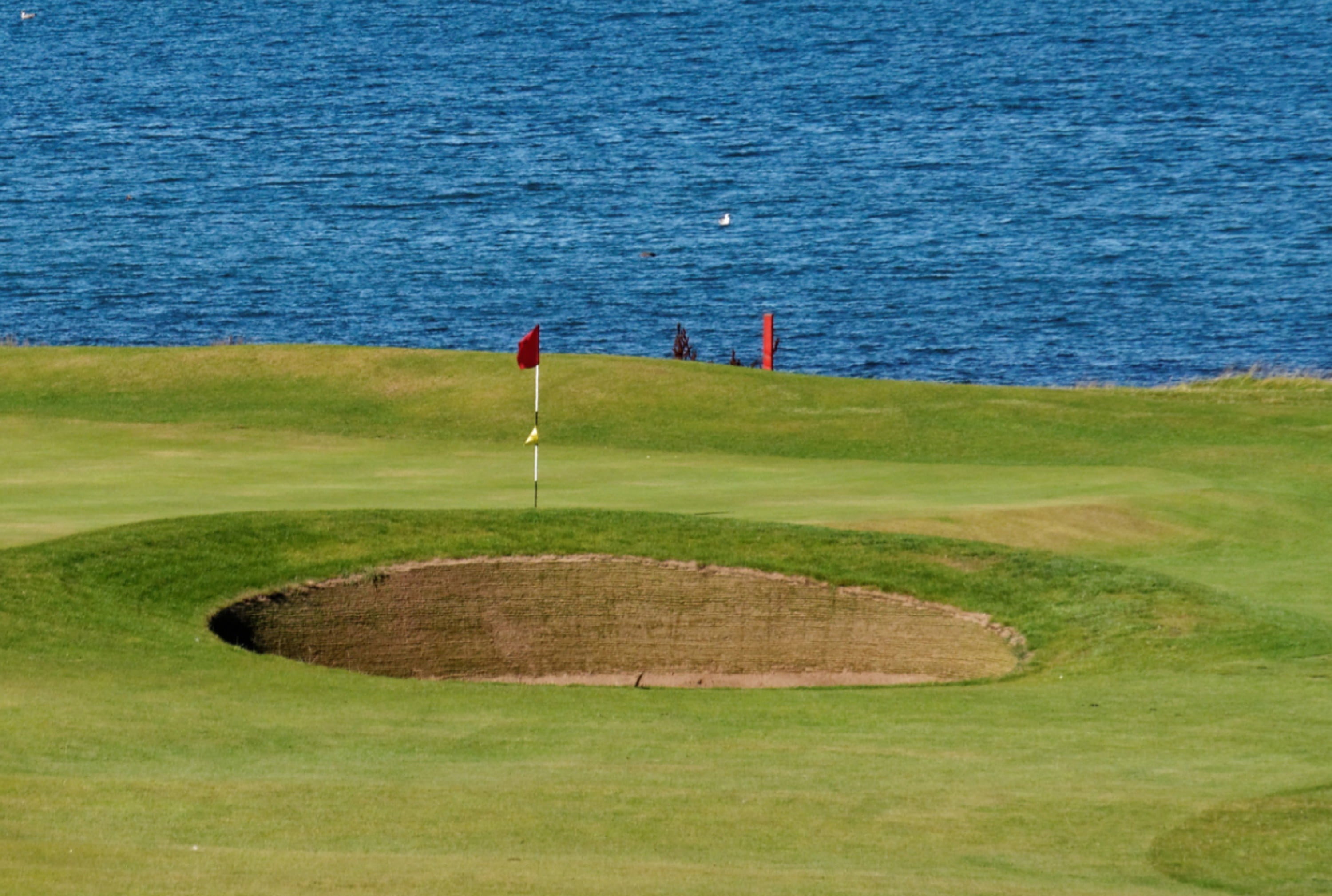 bunker, outdoors, activity, game, hole, east lothian, golf course, beside, golf flag, no people, water, winterfield, sky, green - golf course, leisure activity, HD Wallpaper