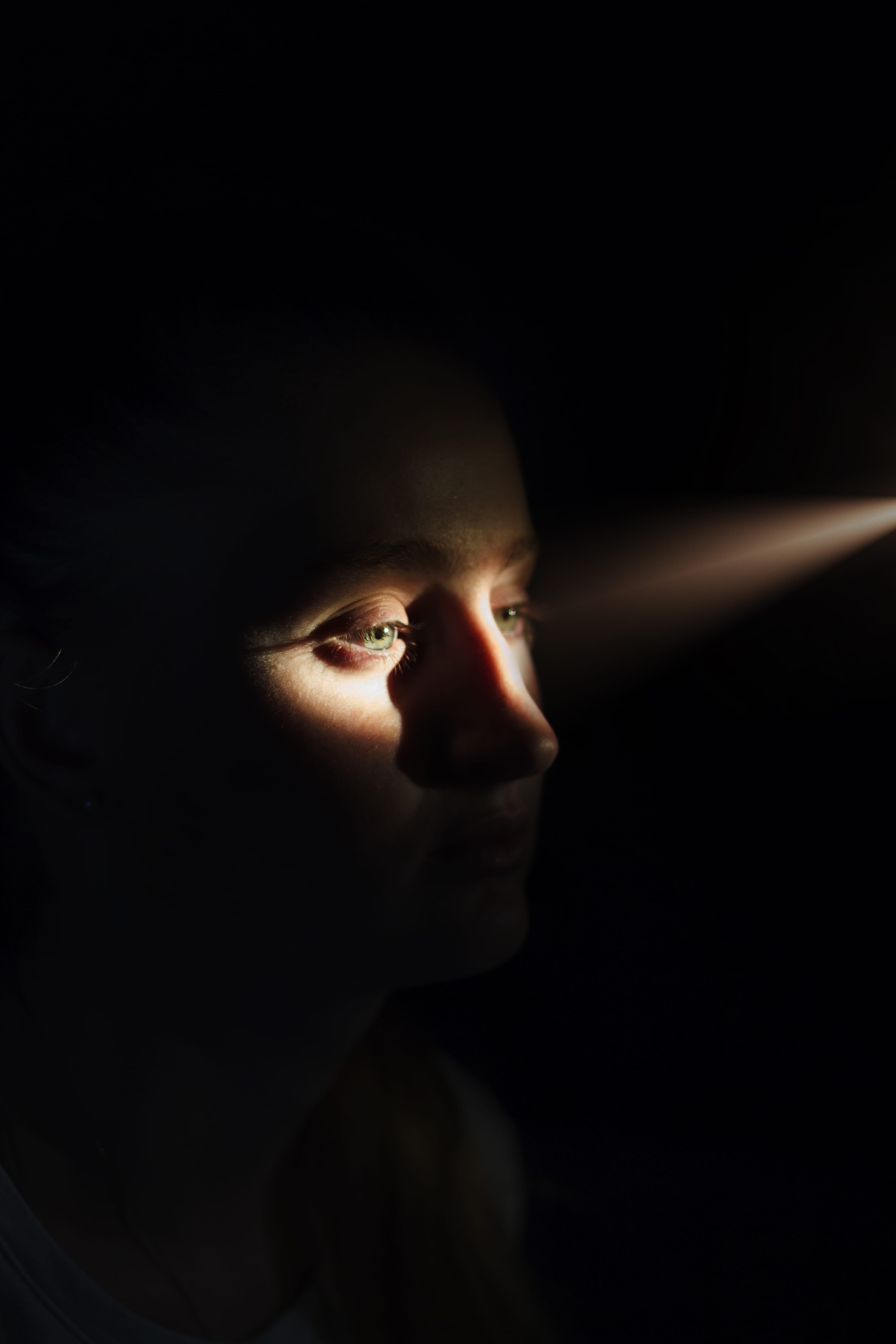 face, human body part, human face, childhood, innocence, sunlight, looking, light, eyes, girl, one person, body part, womans, close, 5K, black background, Phone HD Wallpaper