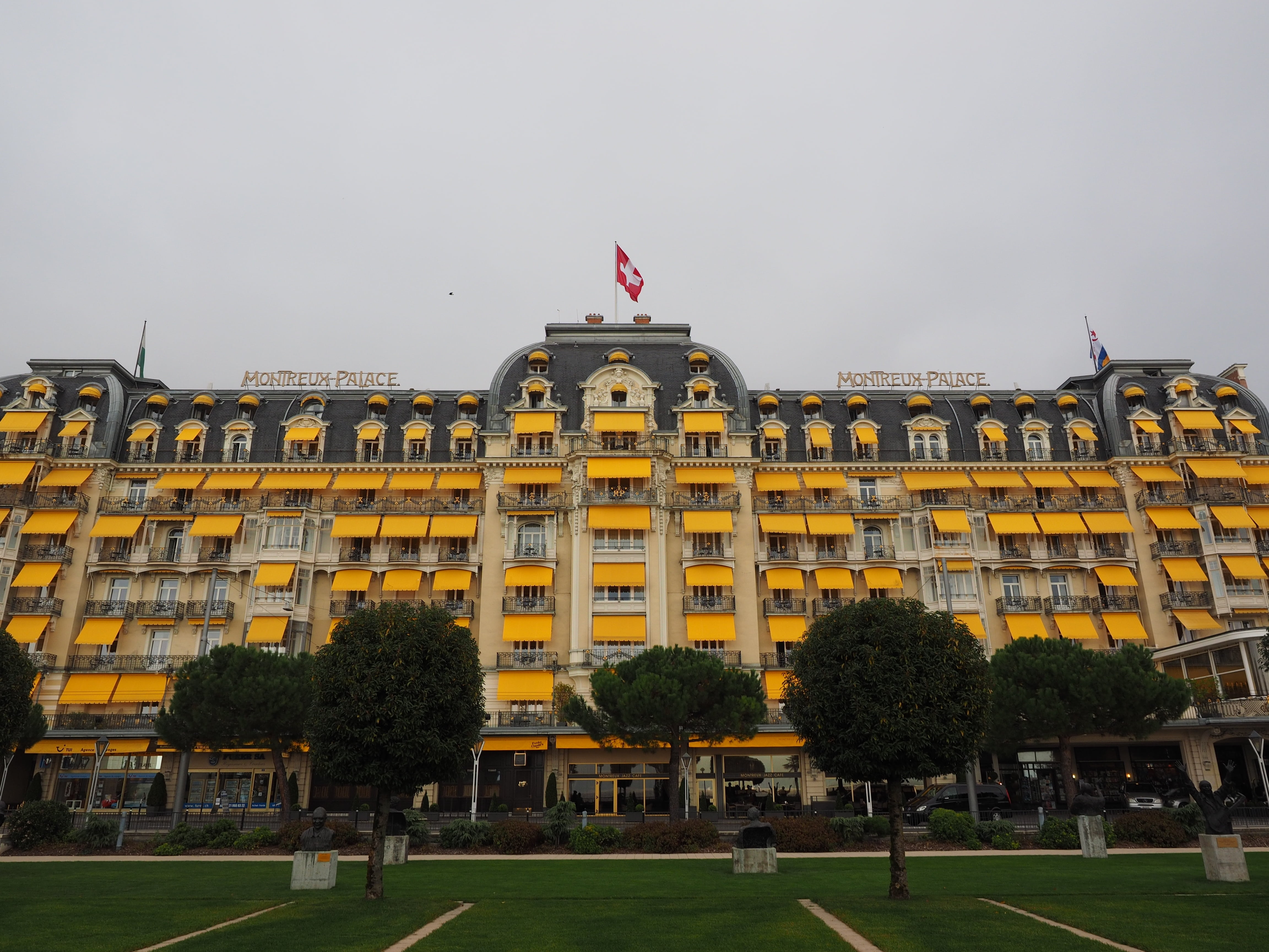 plant, hotel, flag, government, sky, incidental people, city, grass, architecture, travel, tree, building, luxury hotel, yellow, montreux palace, day, building exterior, HD Wallpaper
