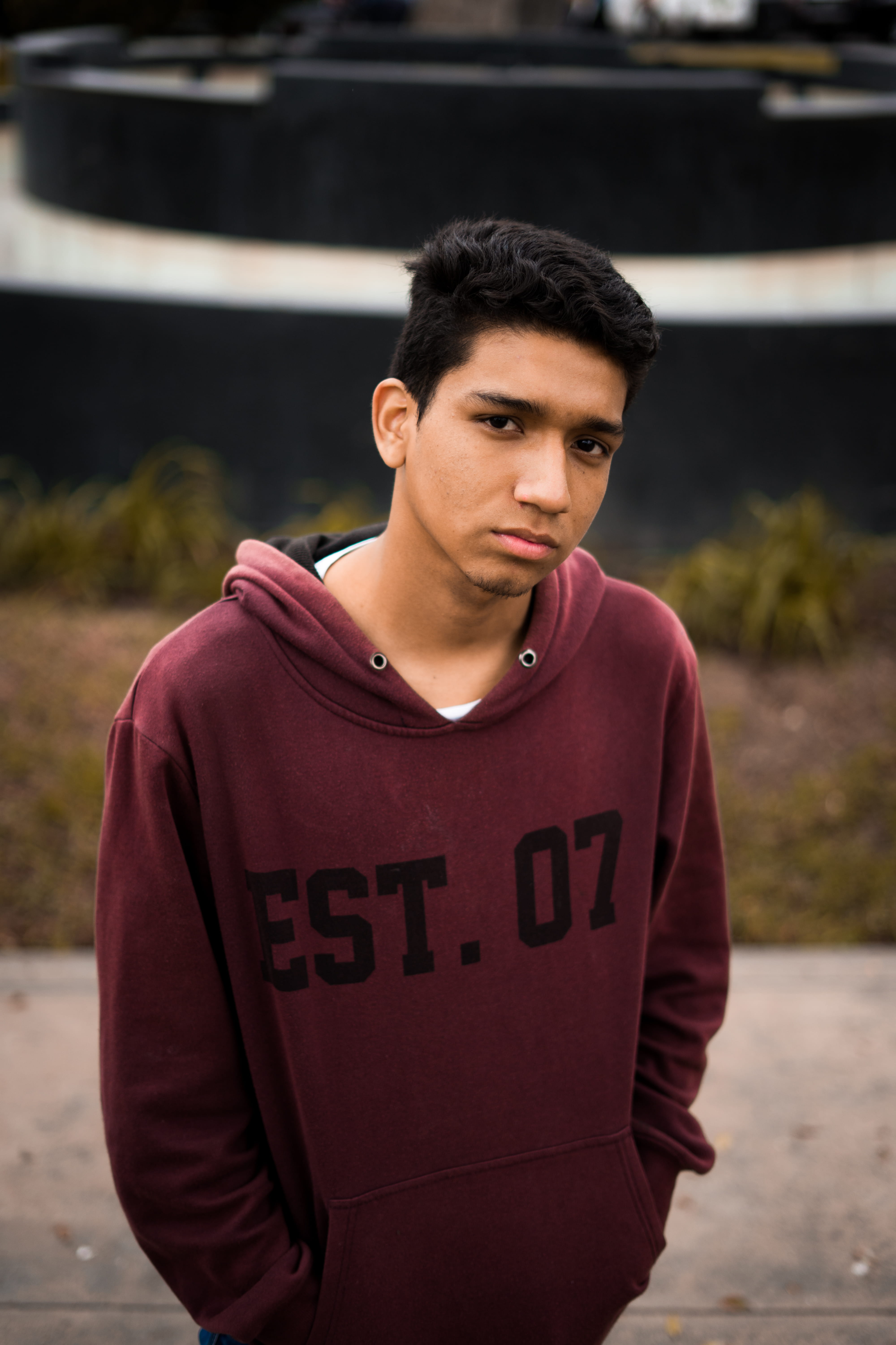 leisure activity, casual clothing, lifestyles, human, maroon, looking at camera, day, waist up, sweatshirt, beautiful people, face, standing, plant, jar, Phone HD Wallpaper