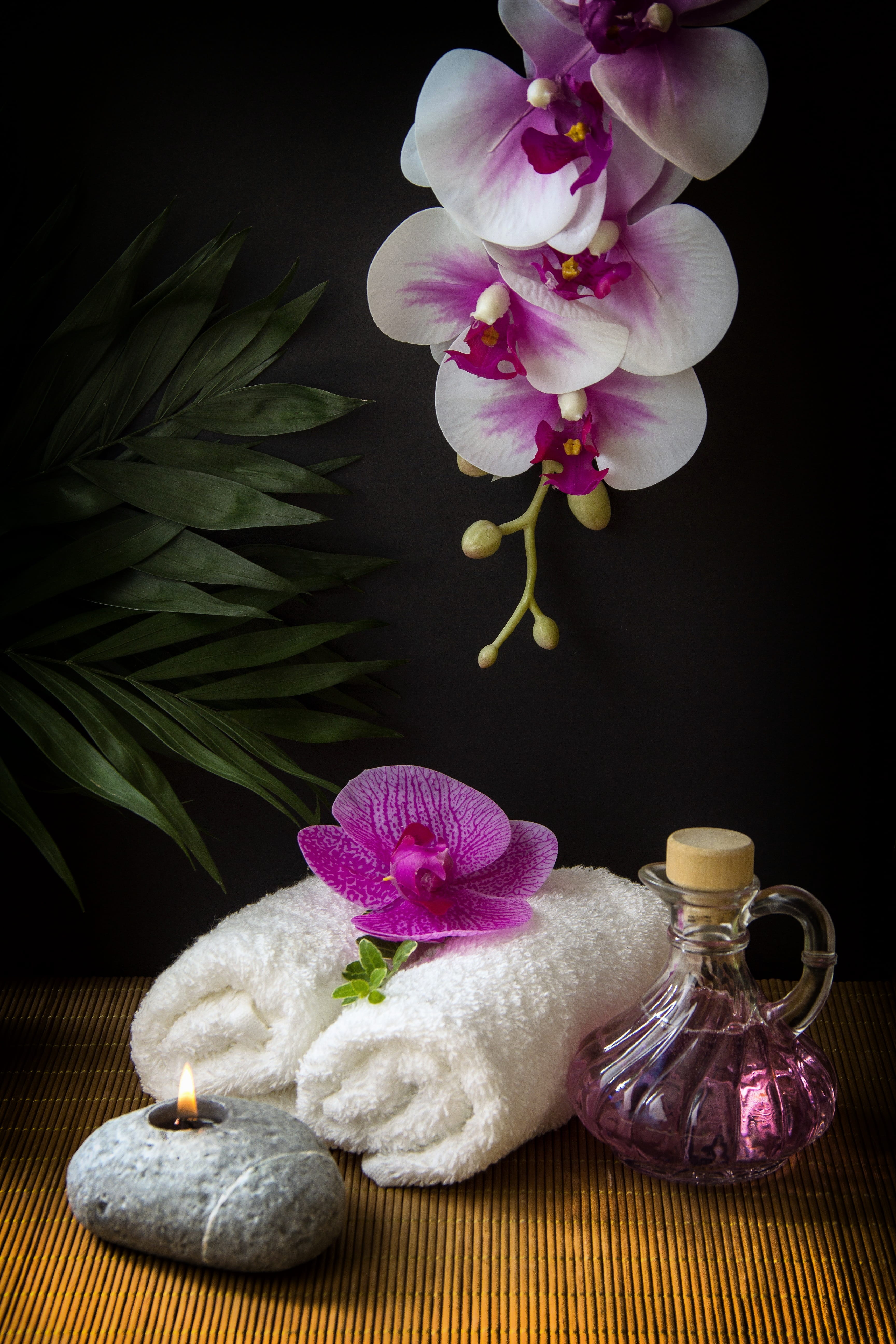 flower head, beauty in nature, towels, glow, table, flower, spa, orchid, softness, plant, indoors, black, rolled, petal, candle, carafe, white, bamboo, Phone HD Wallpaper