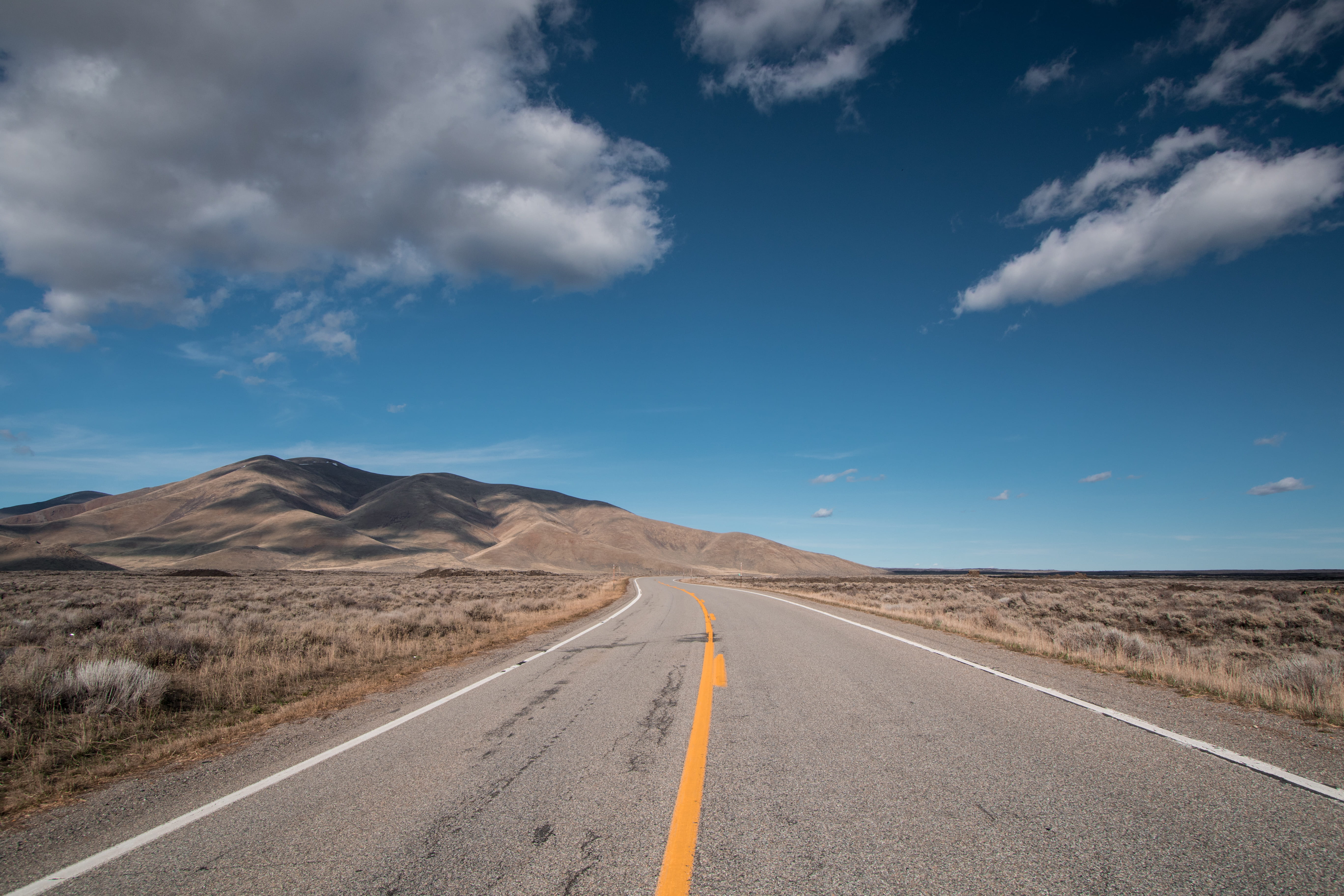 outdoors, road, cloud, travel, beauty in nature, cloud - sky, horizon, environment, empty road, blue, road marking, discover, yellow stripe, symbol, hill, HD Wallpaper