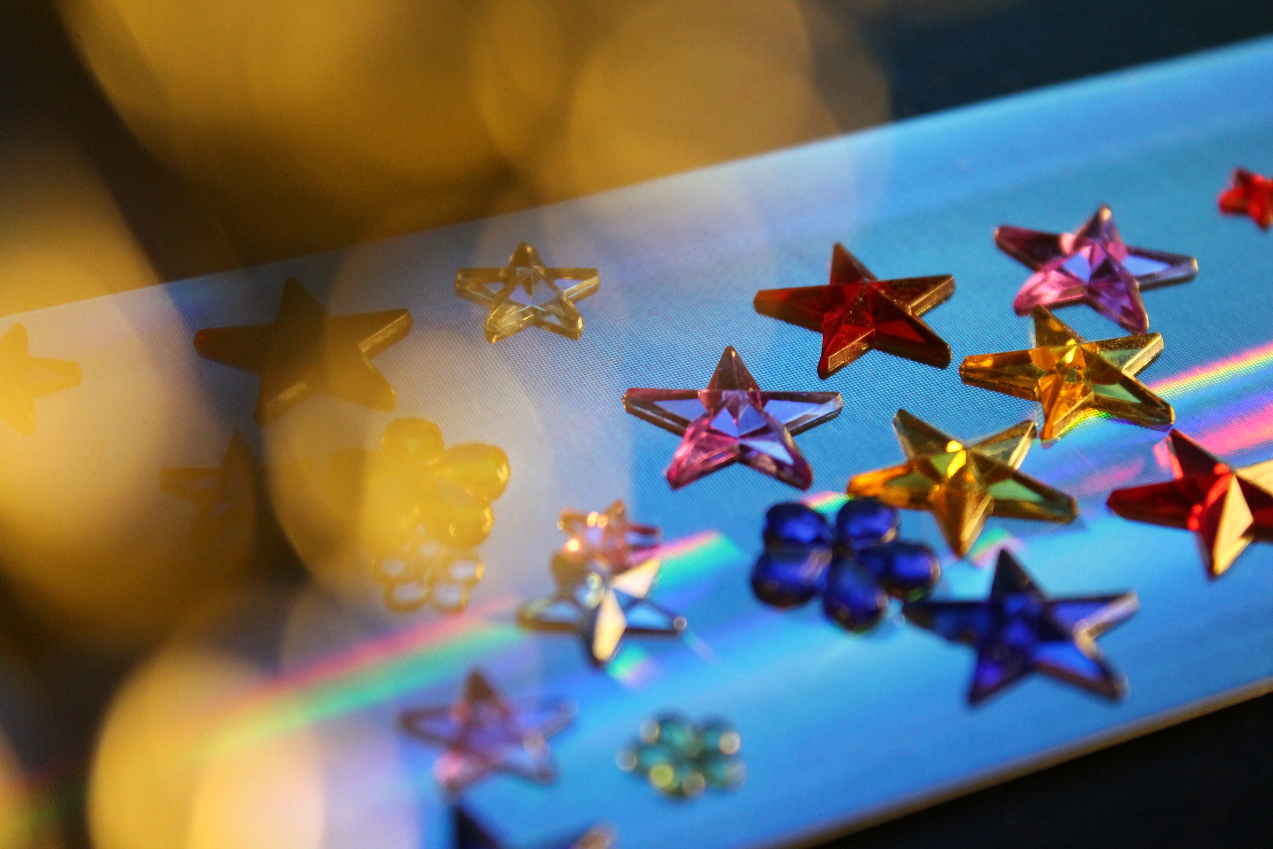 creativity, high angle view, art and craft, shiny, 4K, glitter, glam, close-up, stars, paper, no people, multi colored, shape, decor, holographic, indoors, HD Wallpaper