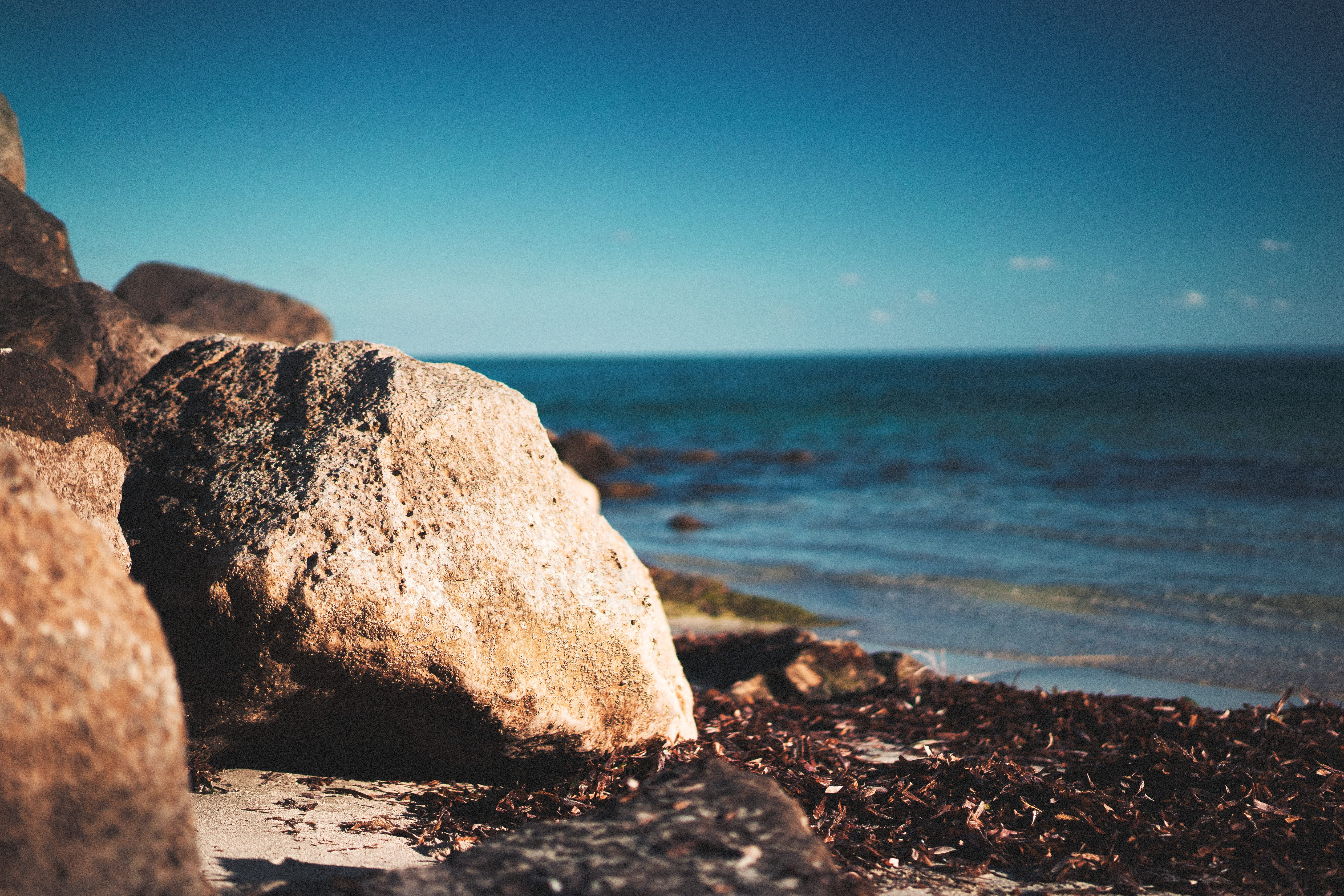 water, sun, tranquility, 5K, rocks, sea, tranquil scene, clear sky, rock - object, land, beach, rock, blue, outdoors, day, no people, horizon over water, HD Wallpaper