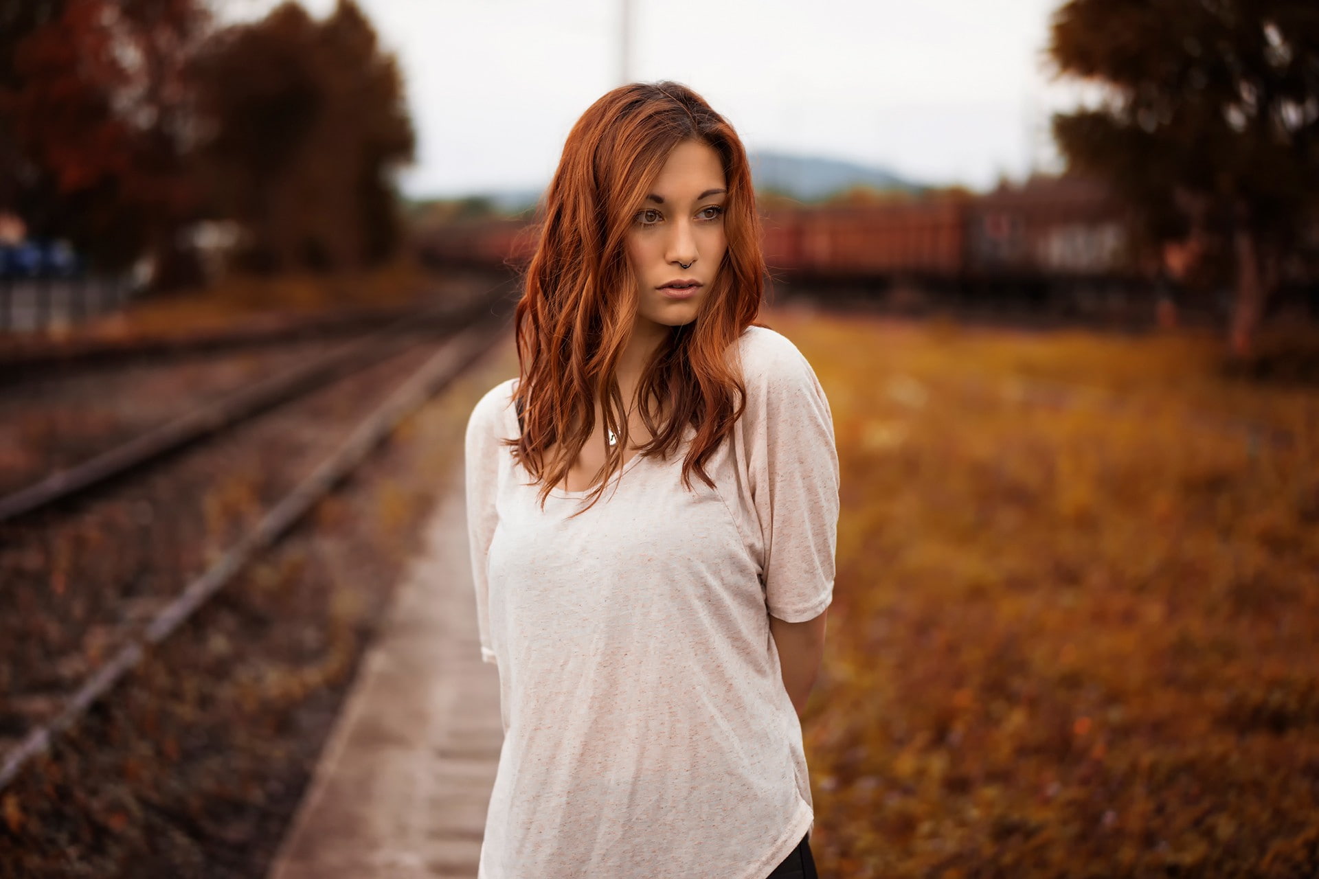T-shirt, Victoria Ryzhevolosaya, long hair, pierced nose, leaves, 1080P, women outdoors, hazel eyes, fall, redhead, railway, model, women, trees, depth, HD Wallpaper