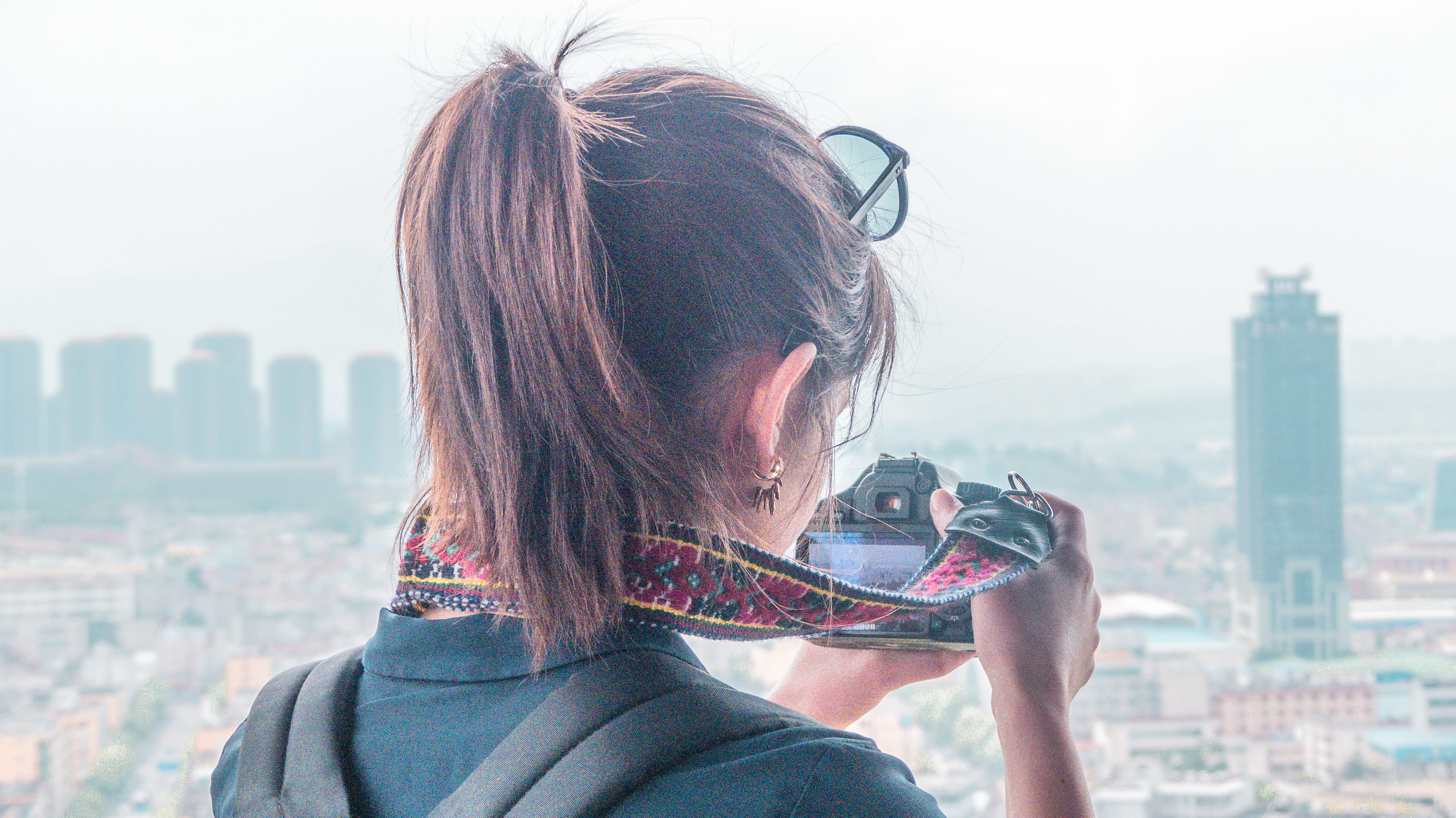 person, holding, headshot, binoculars, city, sunglasses, human, digital camera, photo, face, outdoors, building exterior, hair, portrait, strap, built structure, HD Wallpaper