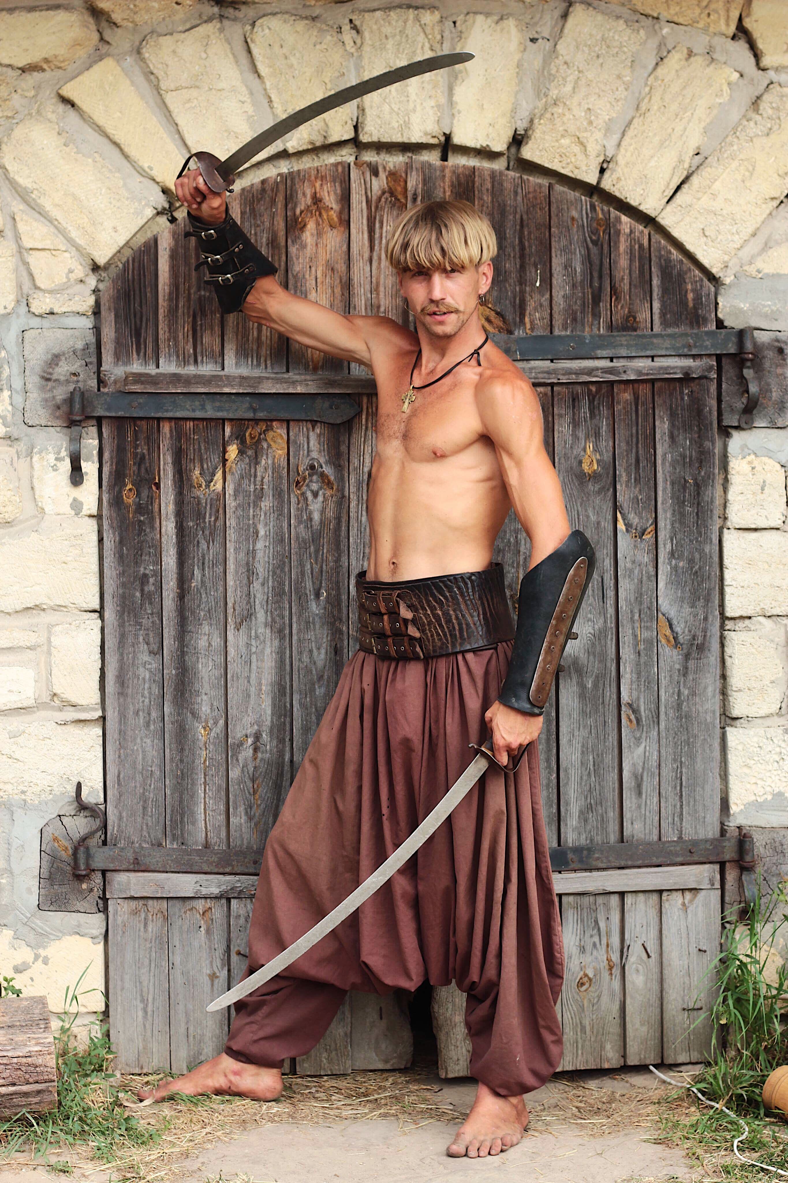 male, cosplay, holding, muscles, wood - material, sword, dressing up, hair, real people, looking at camera, person, full length, building, adult, fashion, Phone HD Wallpaper