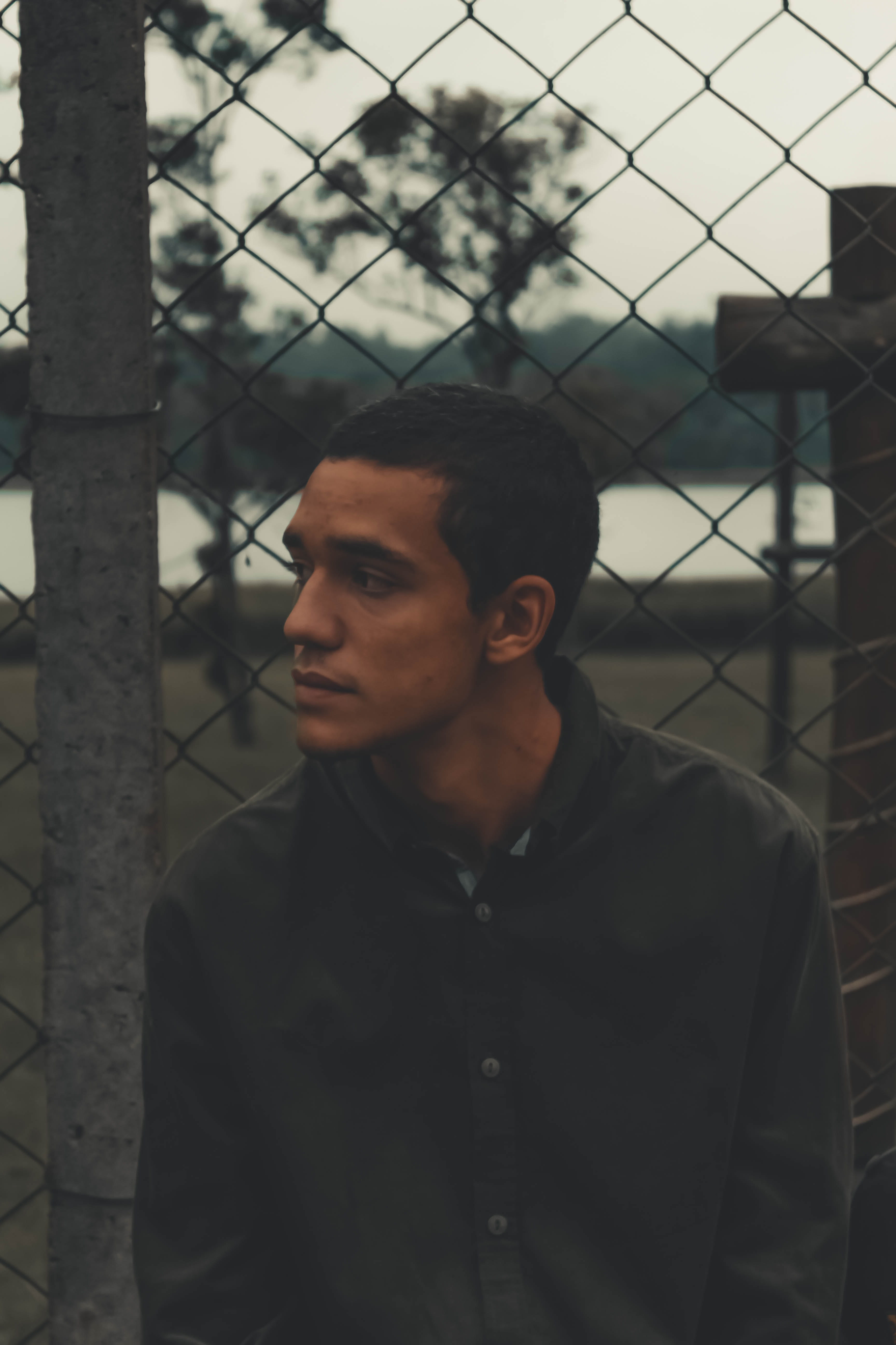facial expression, one person, guy, real people, male, street, focus, sitting, front view, standing, selective, 5K, day, lifestyles, man, looking, fence, Phone HD Wallpaper