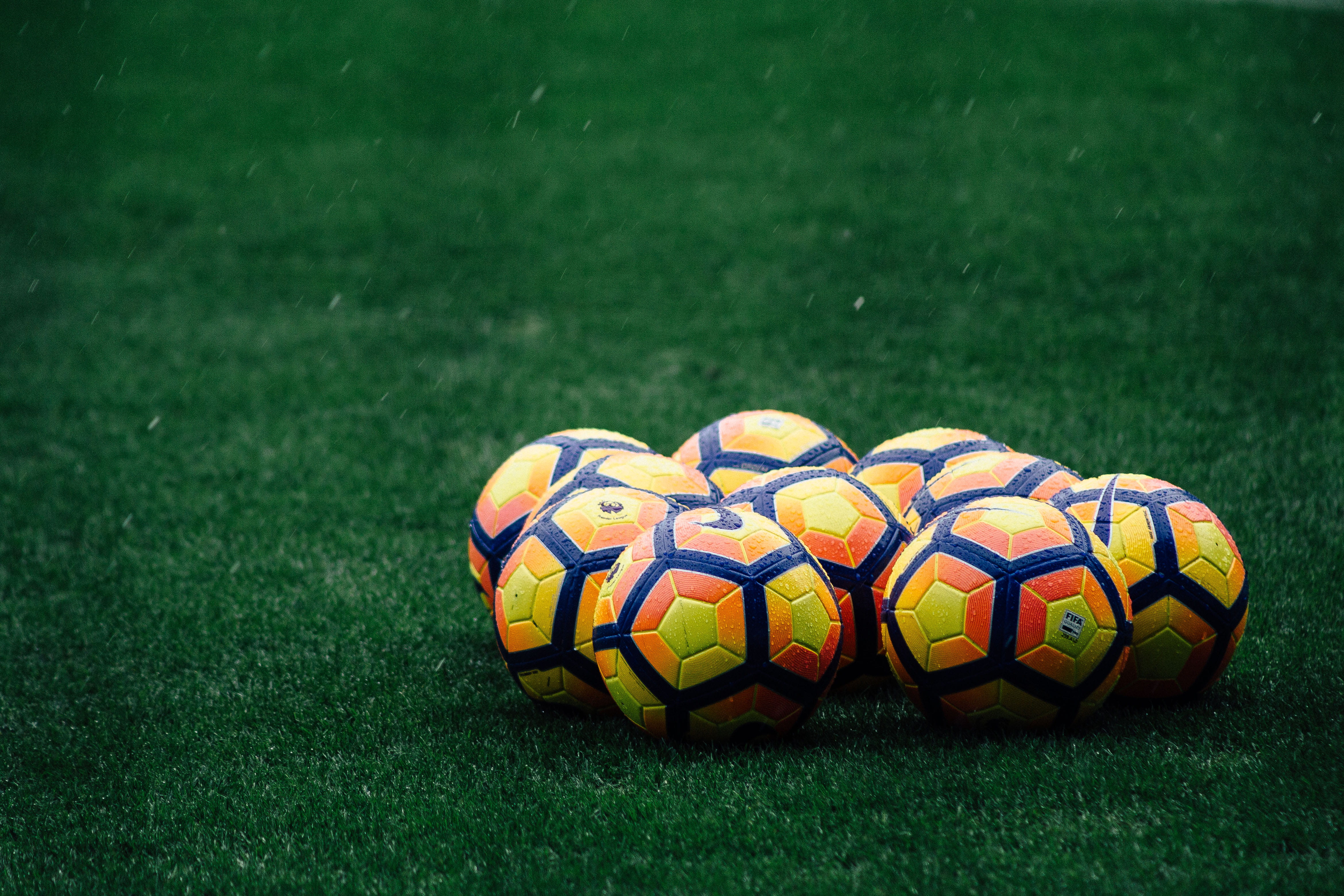 soccer ball, yellow, sports equipment, grass, outdoors, daytime, no people, plant, rain, 4K, multi colored, red, field, pile, team sport, ball, close-up, HD Wallpaper